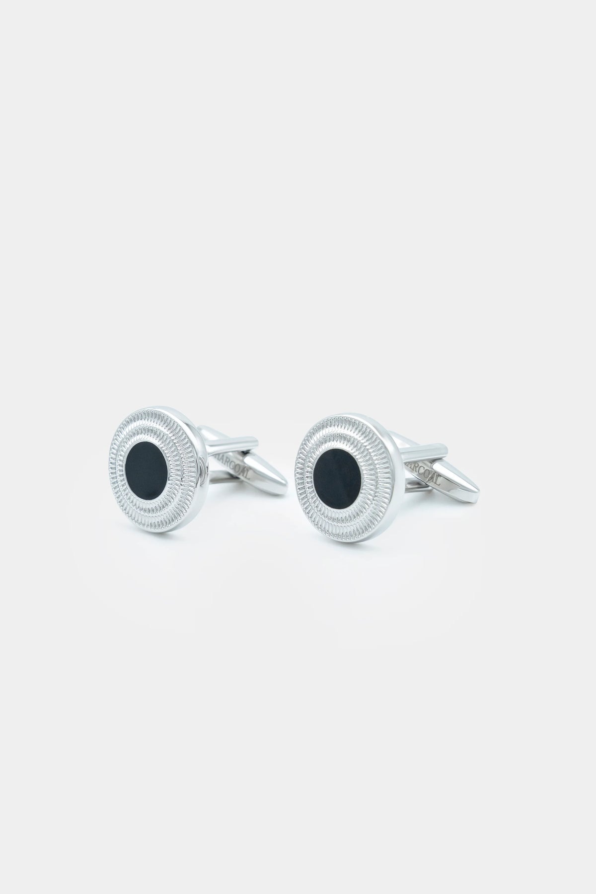 Pair of silver round textured cufflinks with dark centers and pointed posts
