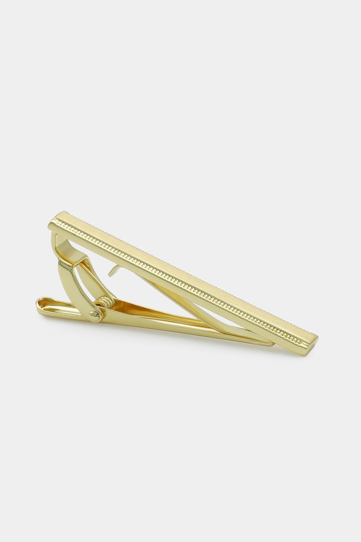 Gold tie bar tie pin with hinged clasp and textured edges, angled view.