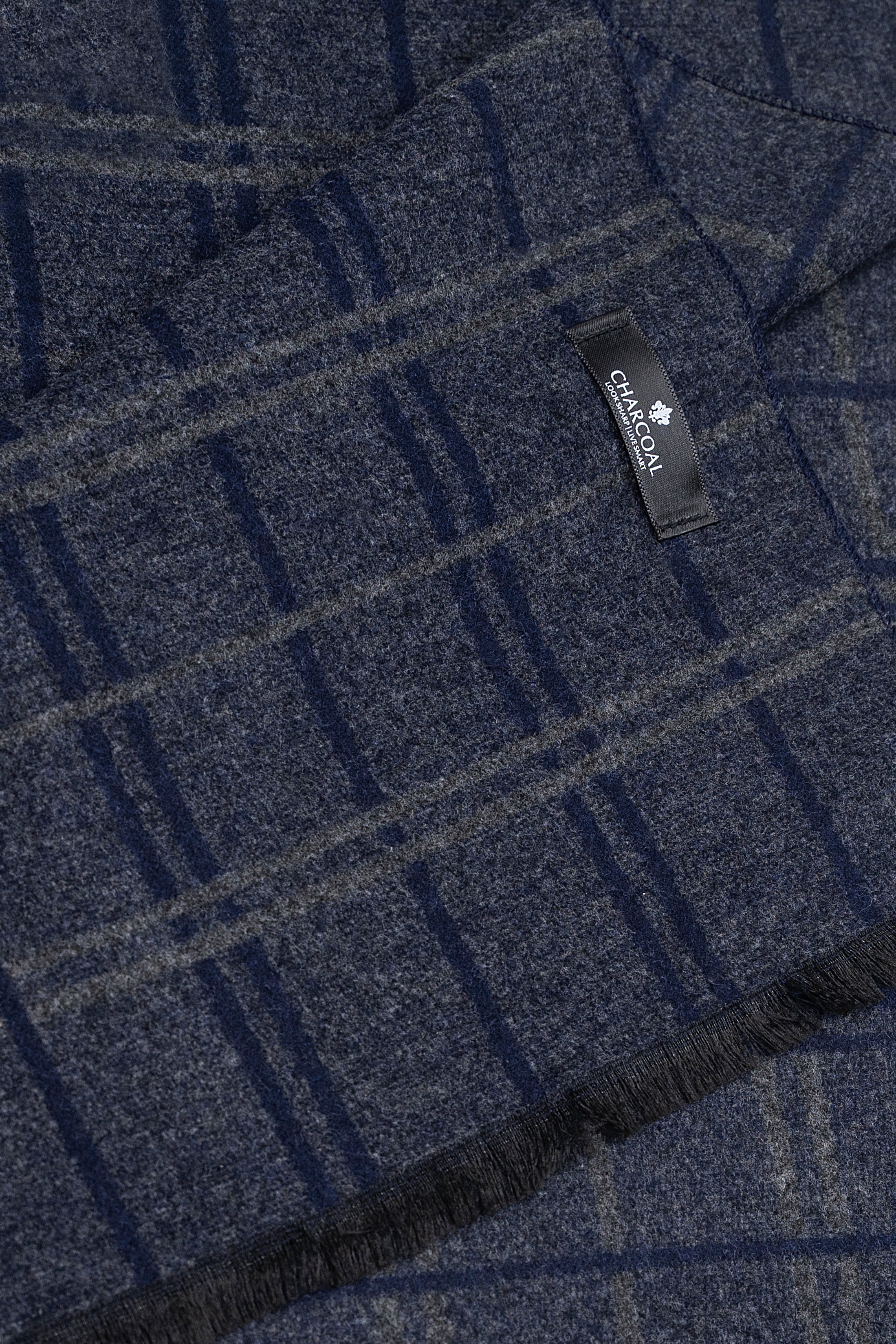 Dark blue plaid scarf close-up with woven texture and brand label