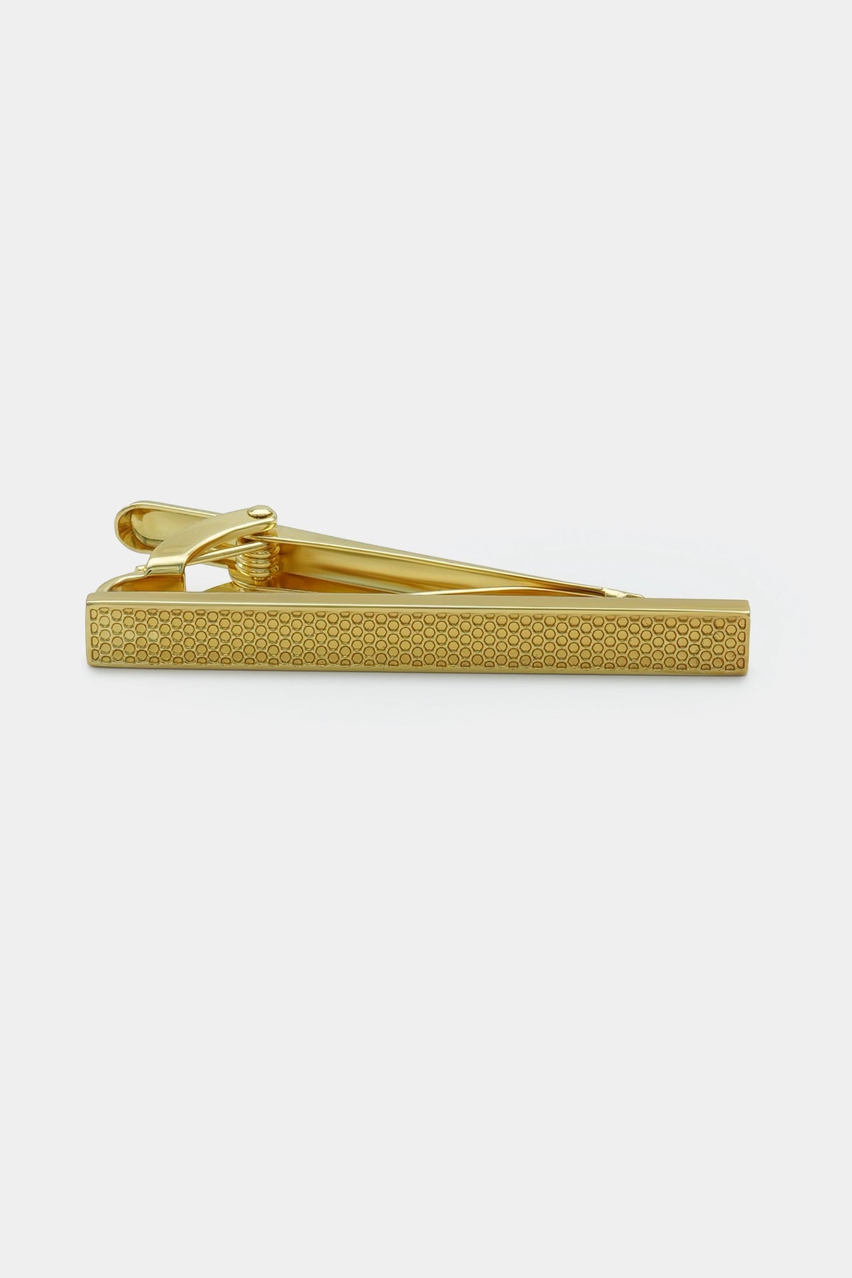 Gold tie pin with textured bar front and clamp back, side view