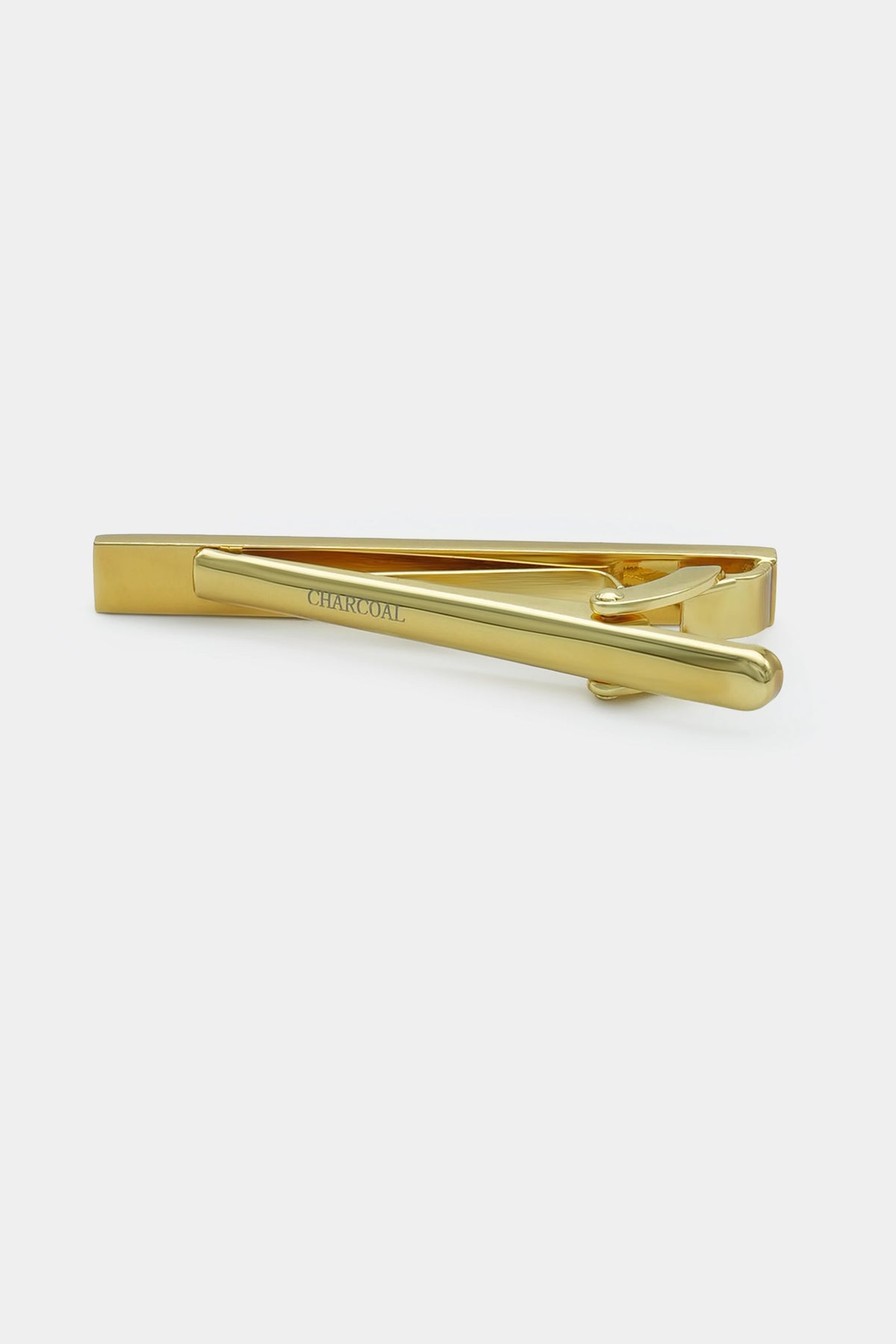 Gold tie pin with smooth bar and hinged clamp, close side view