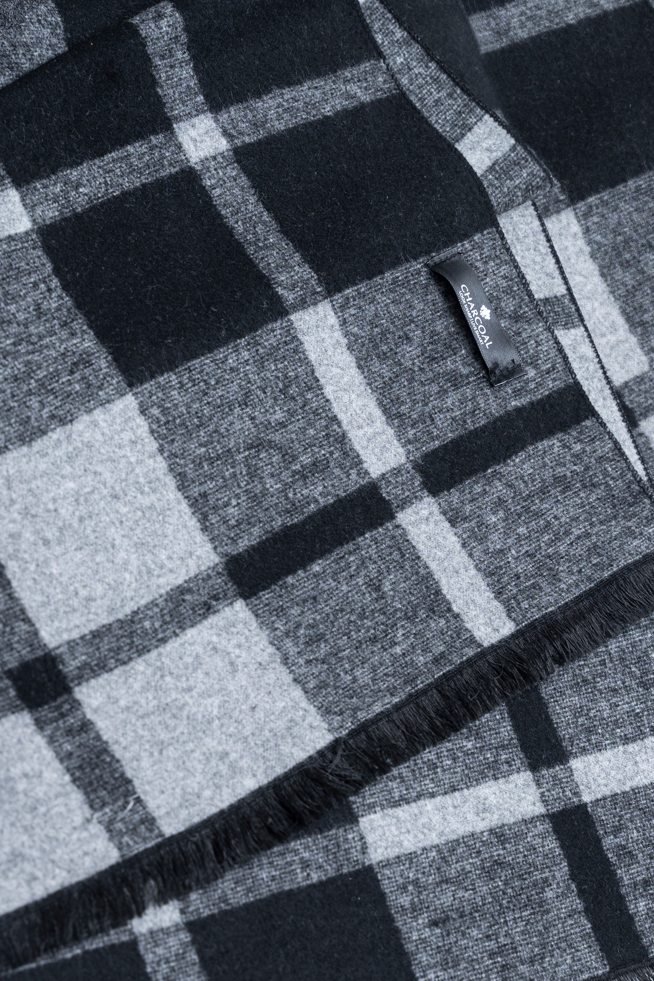 Plaid scarf fabric close-up in gray tones with stitched label