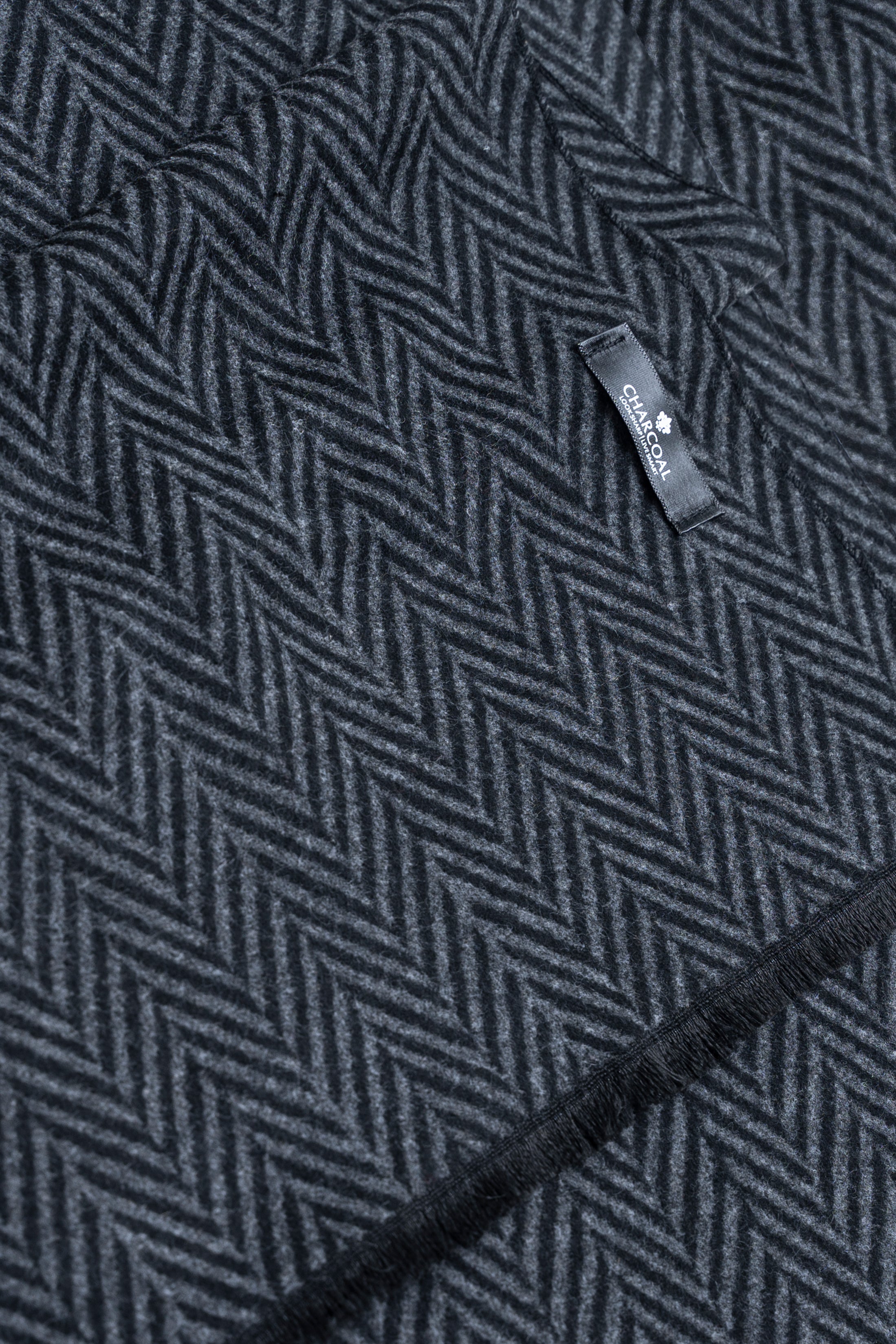 Dark herringbone scarf close-up with fabric pattern and woven brand tag