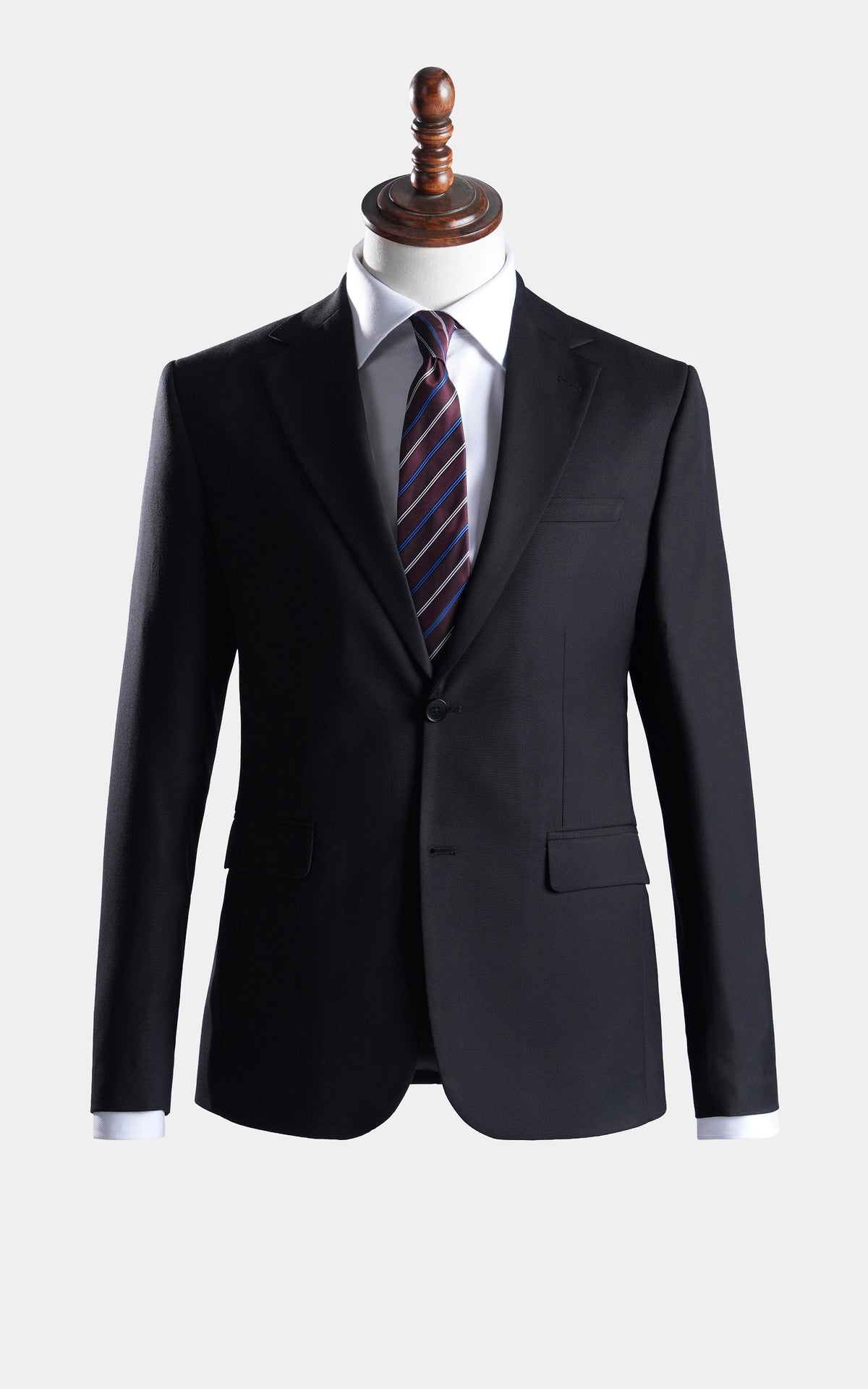 Black two-piece suit jacket and trousers on mannequin, notch lapels and striped tie