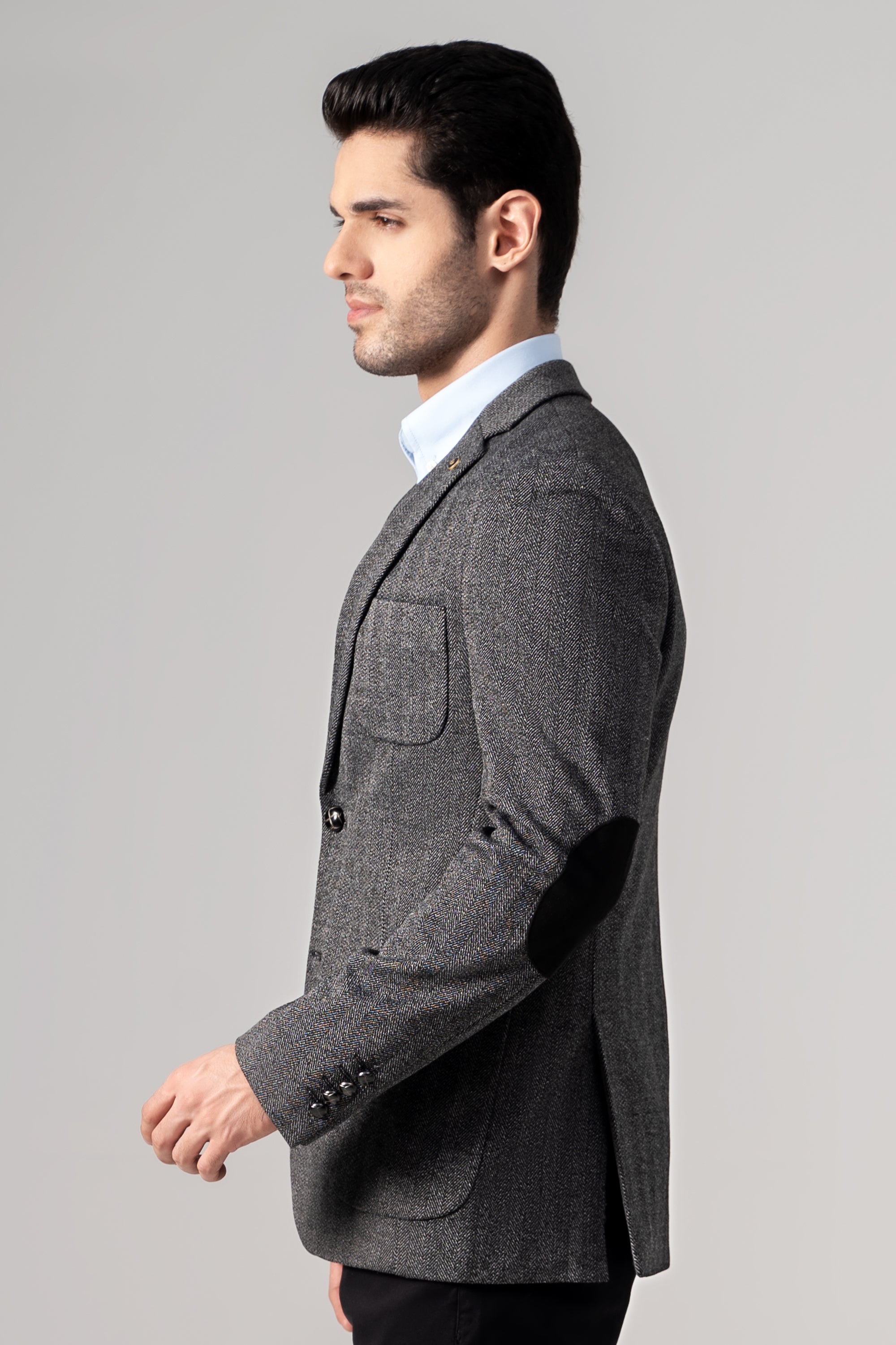 Casual coat in dark herringbone texture with side pocket detail, side view