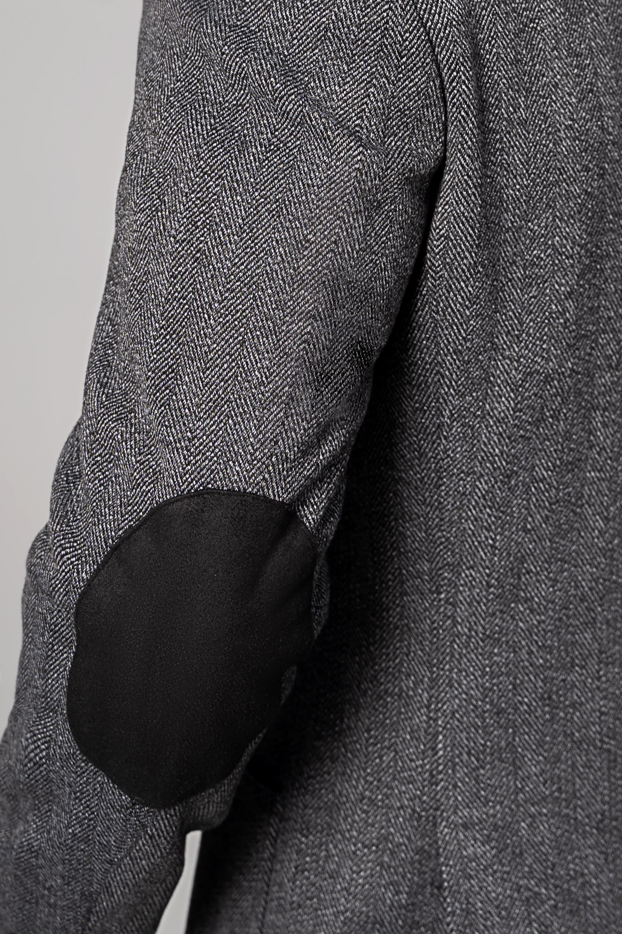 Casual coat sleeve with dark elbow patch and textured herringbone fabric
