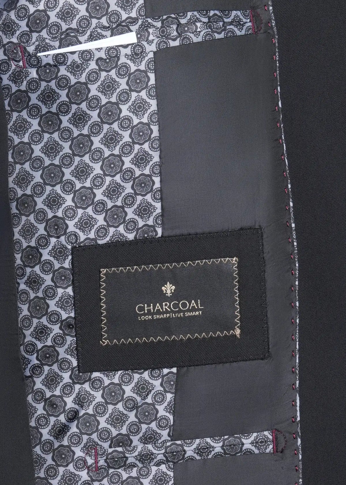 Black suit inner label area with patterned lining and red-stitched edge