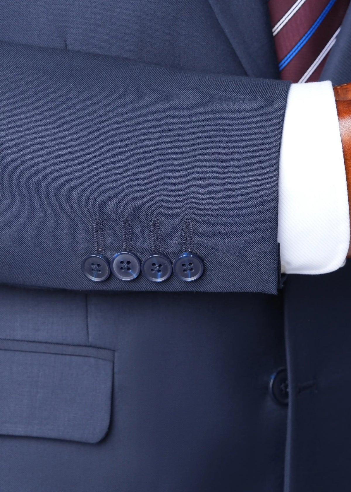 Navy blazer front buttons and pocket detail, with matching trousers at cuff