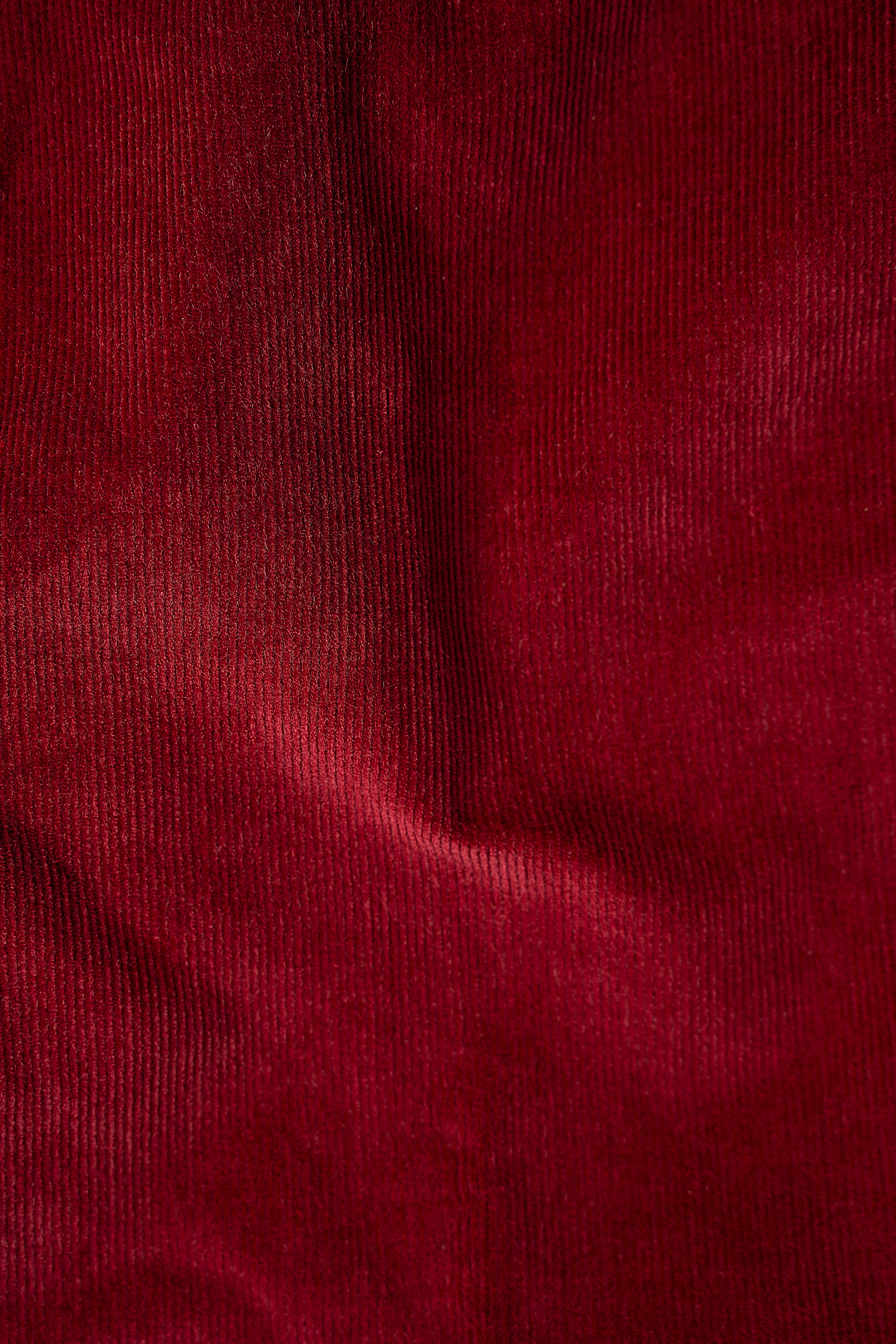 Maroon corduroy fabric close-up with fine ribbed texture