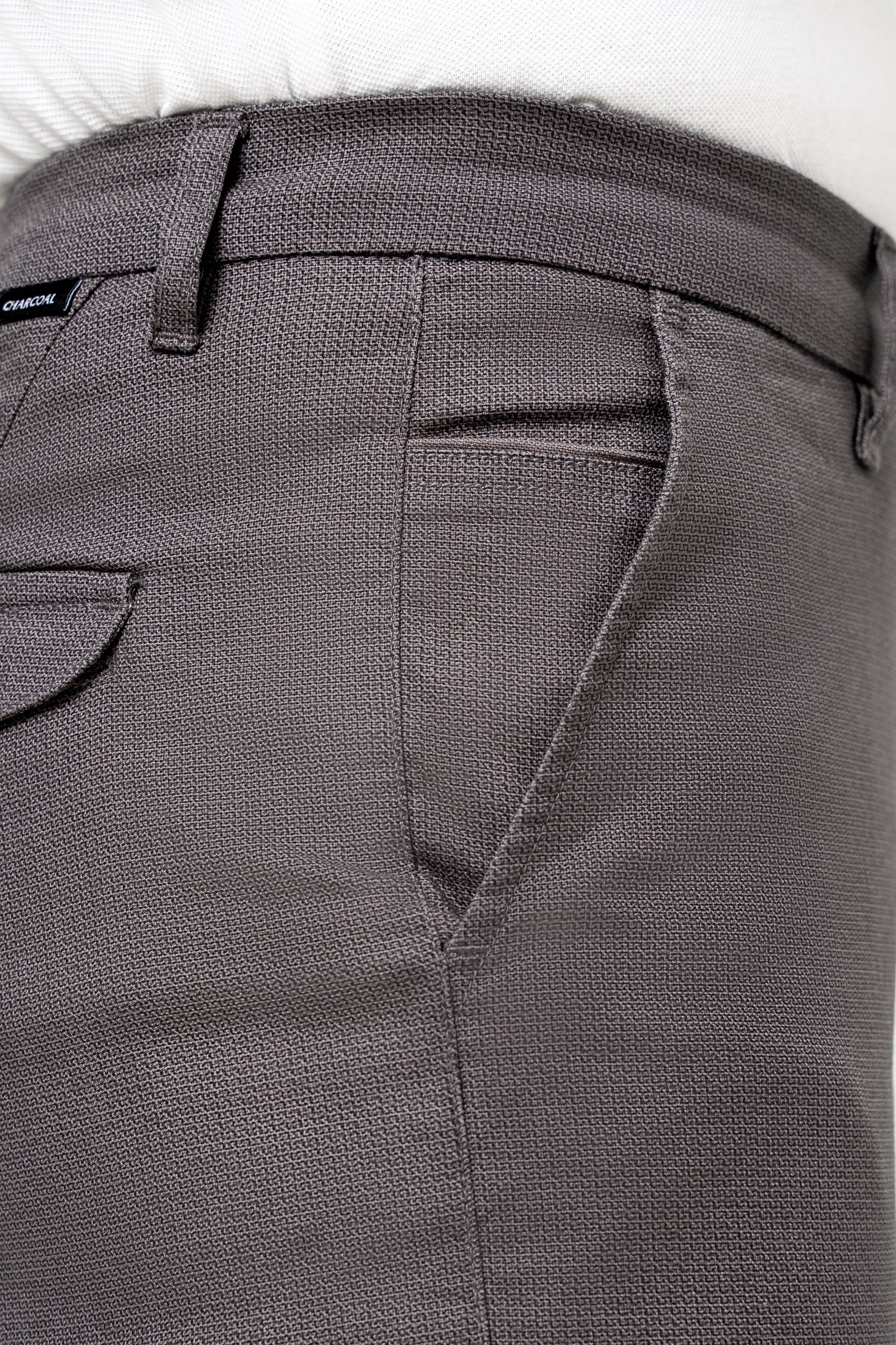 Dark grey trouser waistband with belt loops and front pocket detail