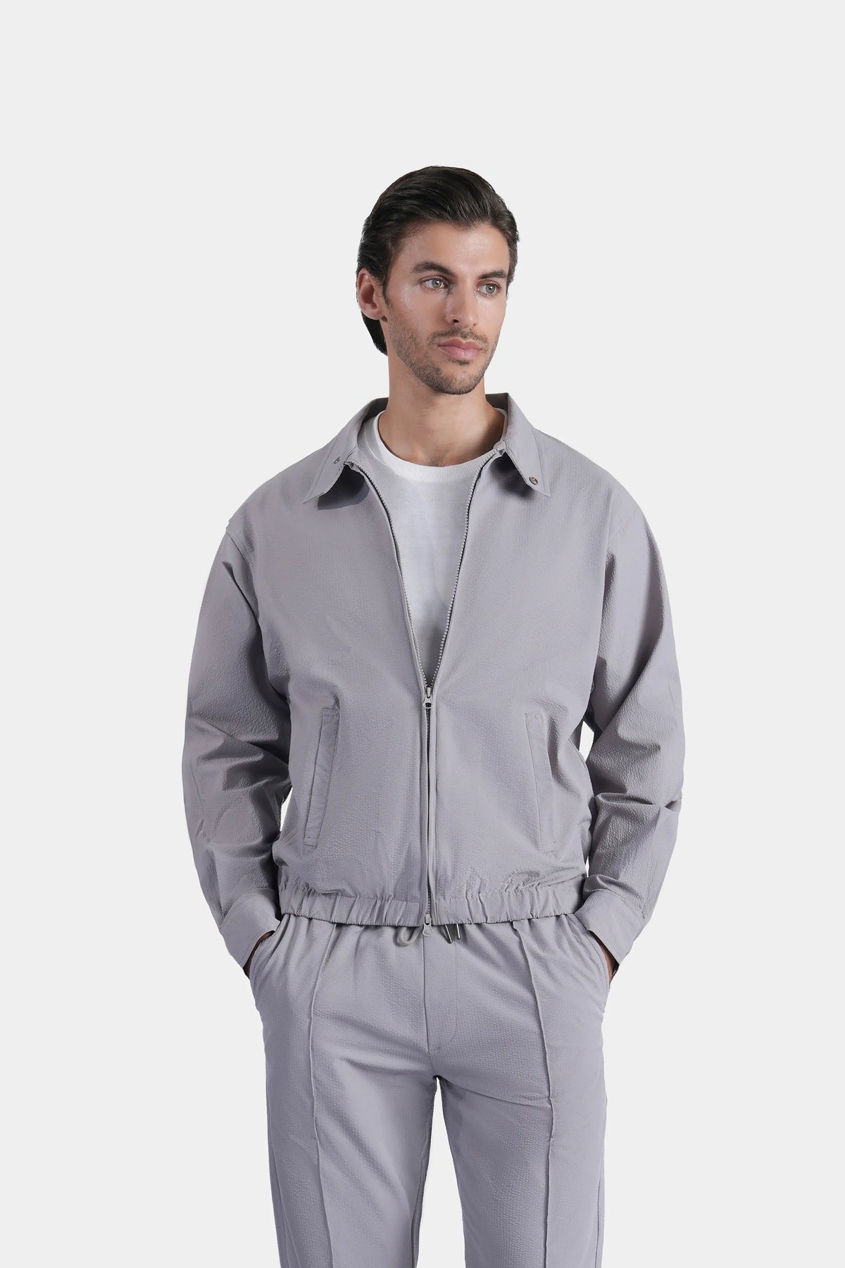 Light grey raglan jacket with full zip front, stand collar, and elastic hem
