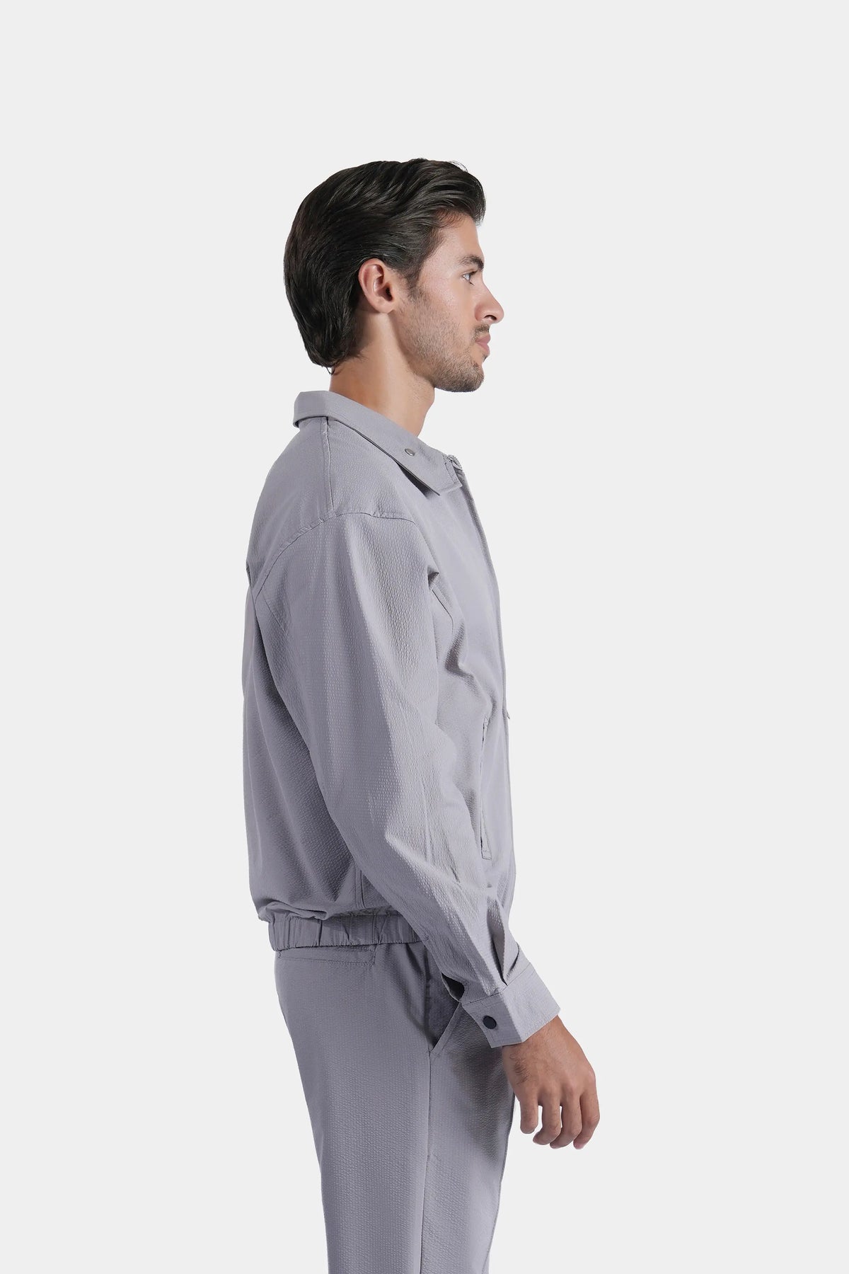 Light grey raglan zip-up jacket with stand collar, side pocket, and elastic waist
