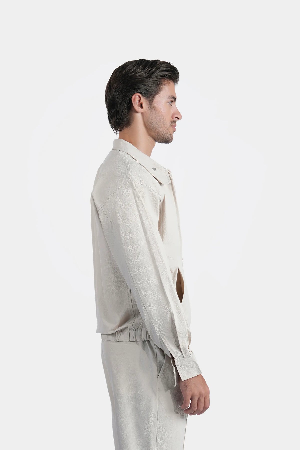 Beige seersucker raglan jacket, side profile with zip closure and stand collar