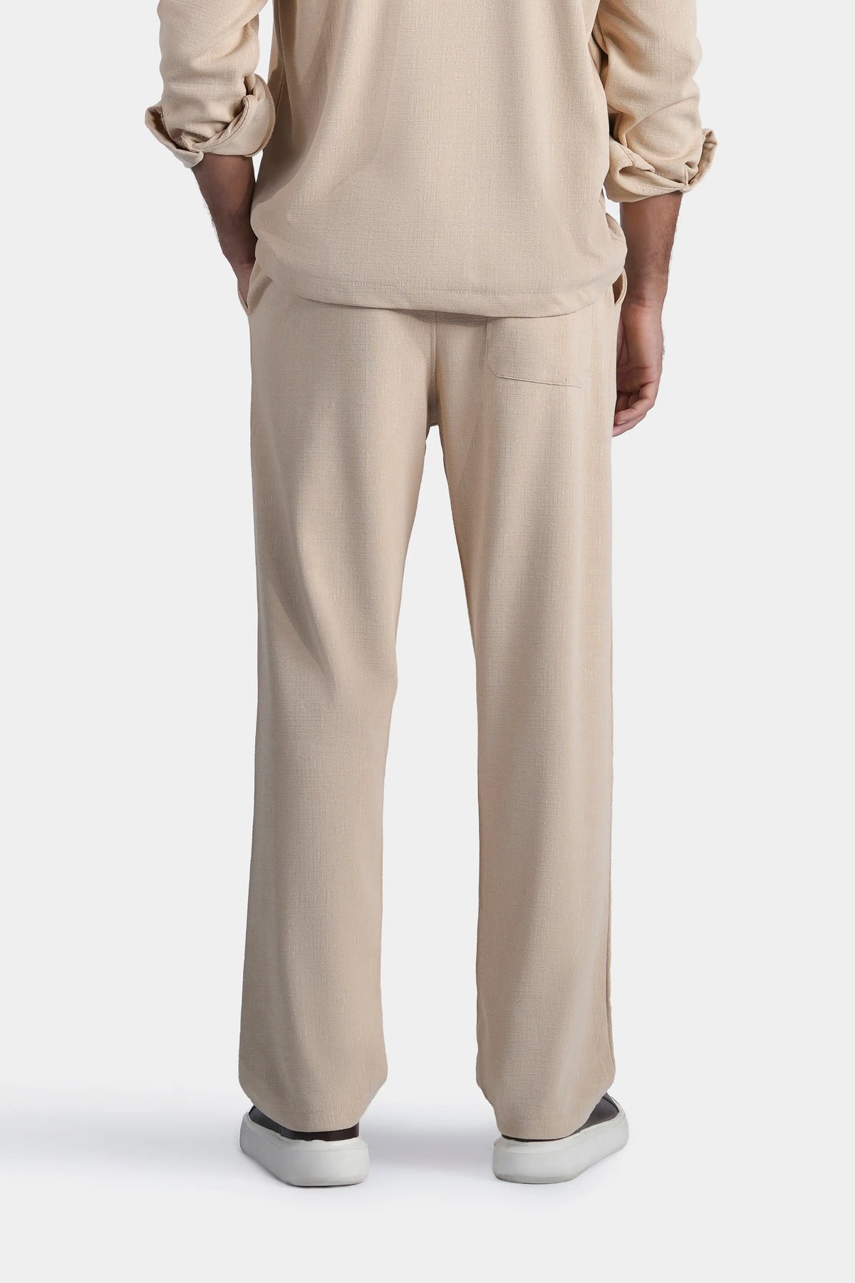 Beige loose-fit trousers, full length view, straight leg and smooth waistband