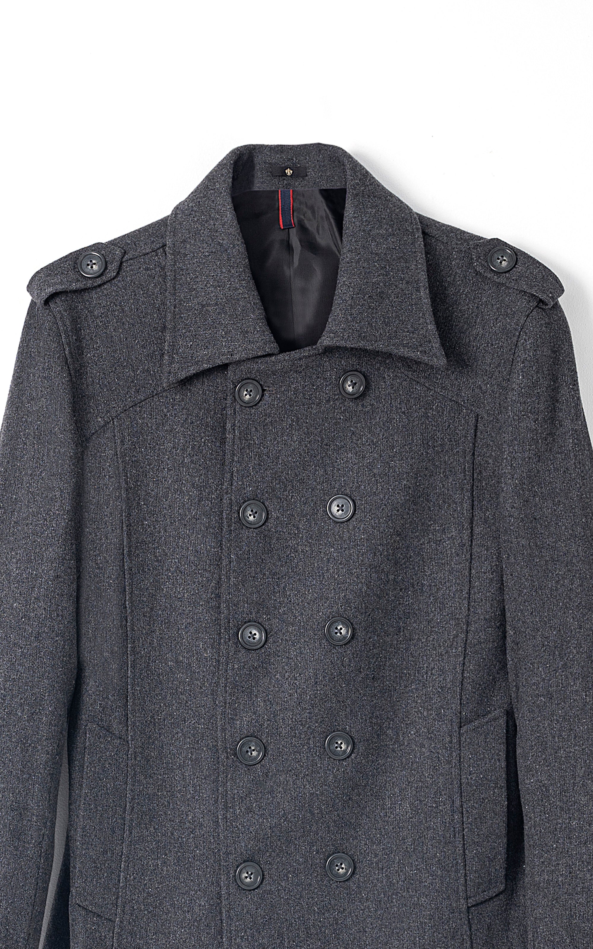 Double-breasted long coat close-up in dark grey with double button placket and epaulettes