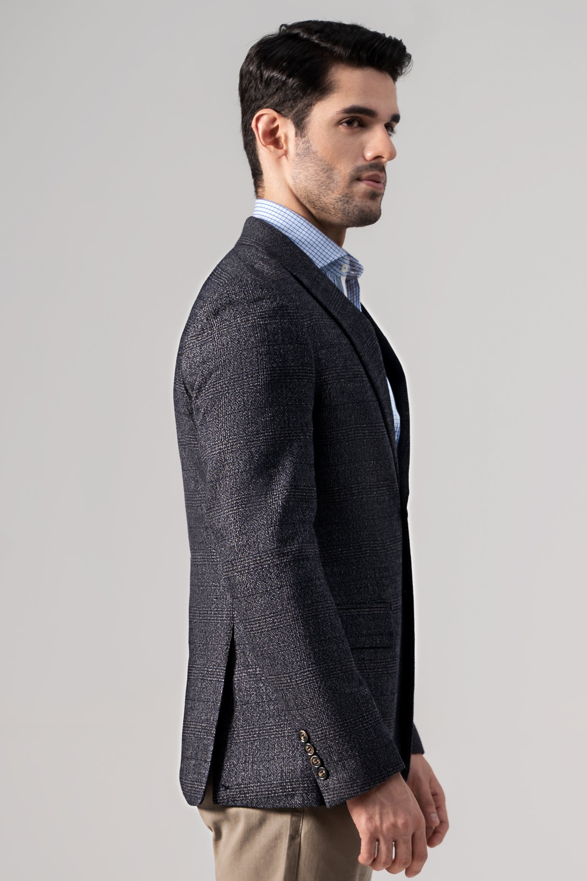 Bluish grey casual coat on model, side view with buttoned front and sleeves.