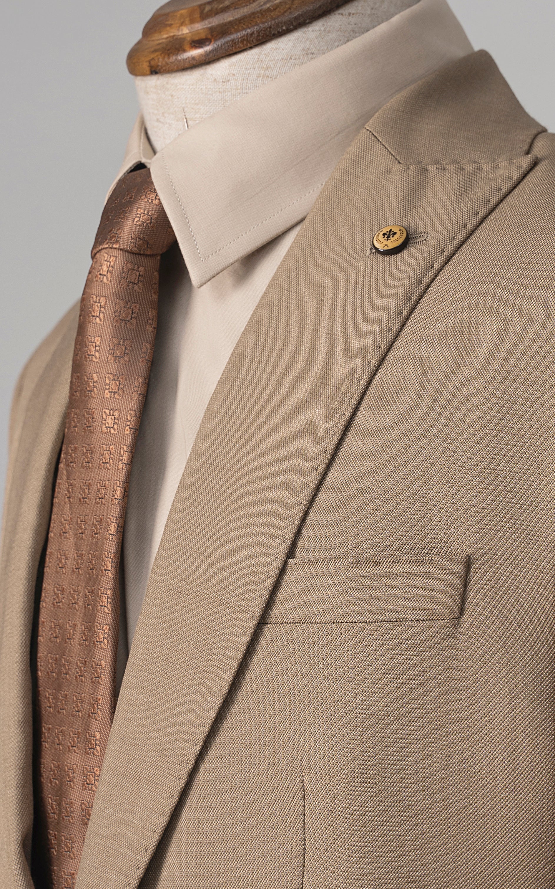 Khaki suit jacket lapel and chest pocket with gold button detail and folded collar