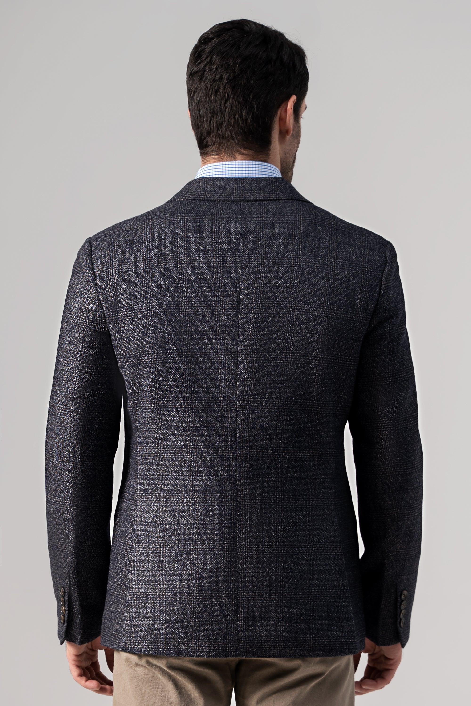 Bluish grey casual coat, back view with center back seam and buttoned cuffs.