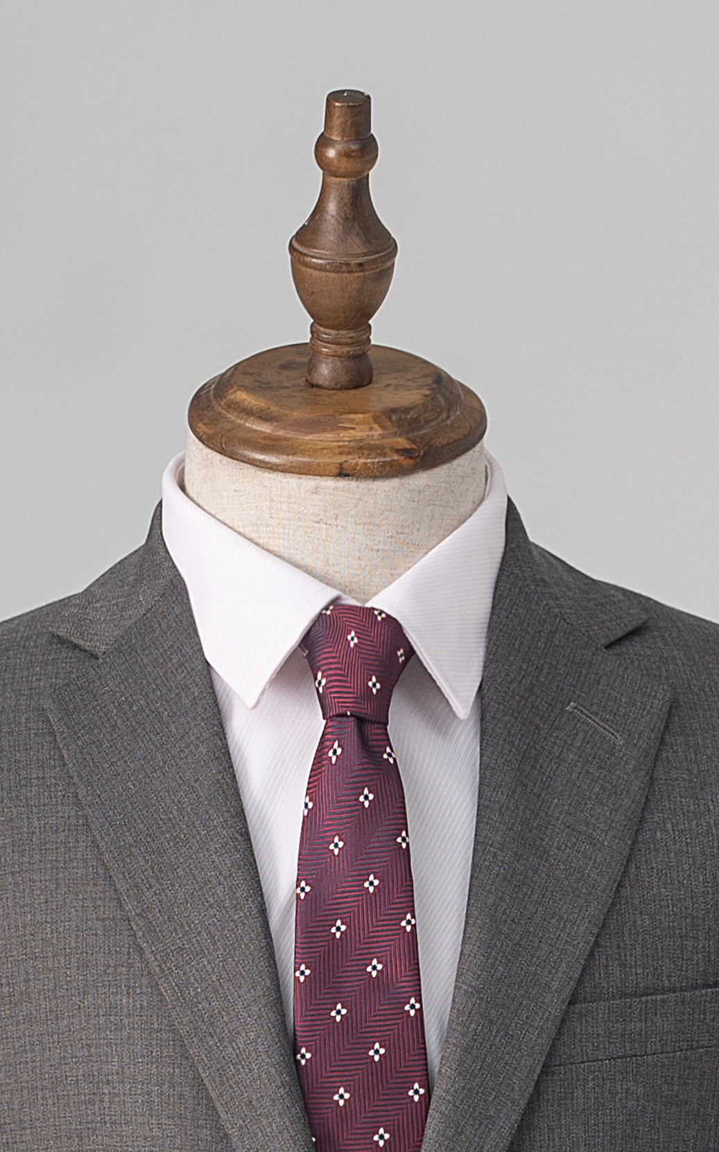 Grey suit jacket with maroon patterned tie, collar and lapel close-up
