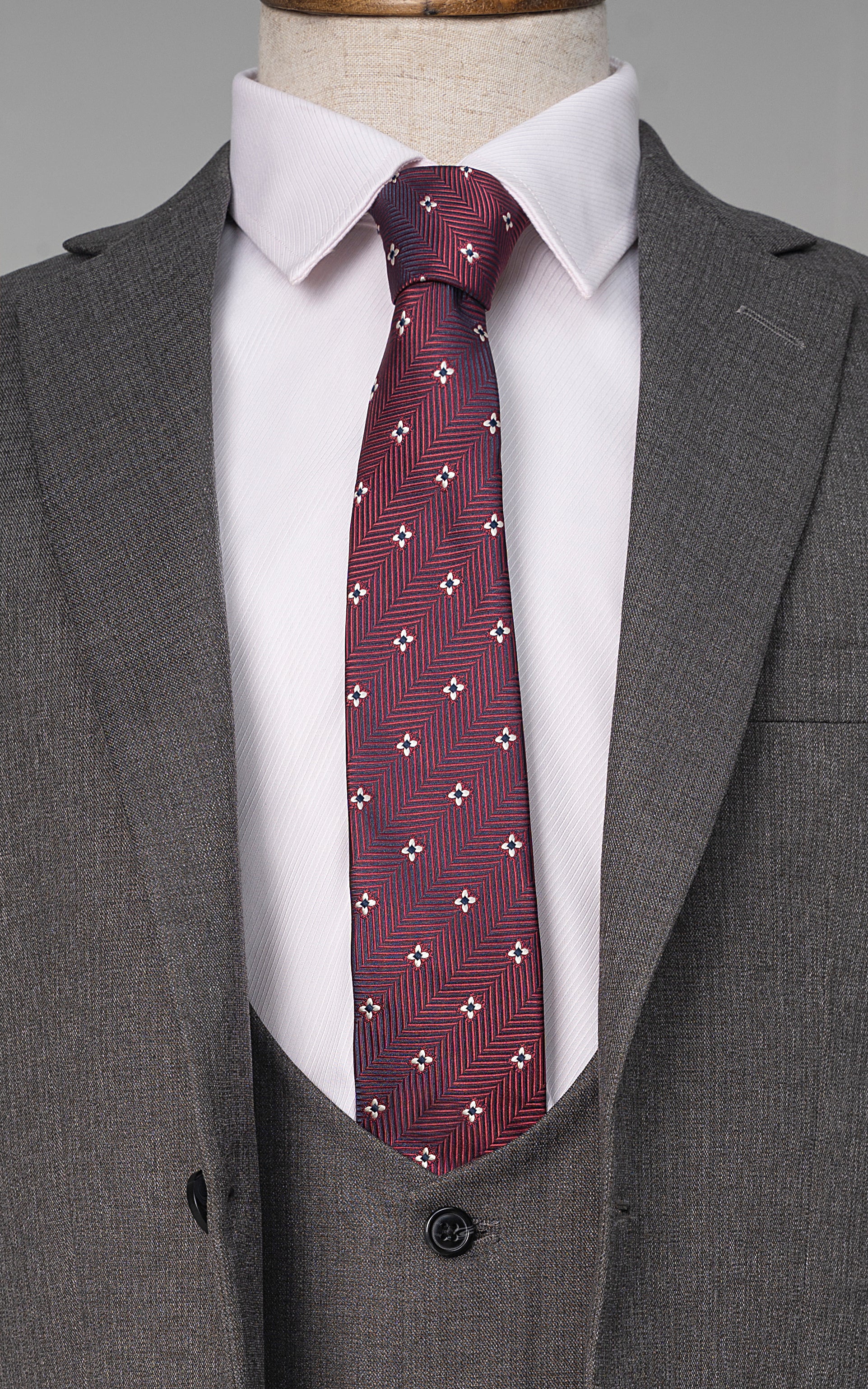 Grey suit jacket with maroon patterned necktie and white dress shirt