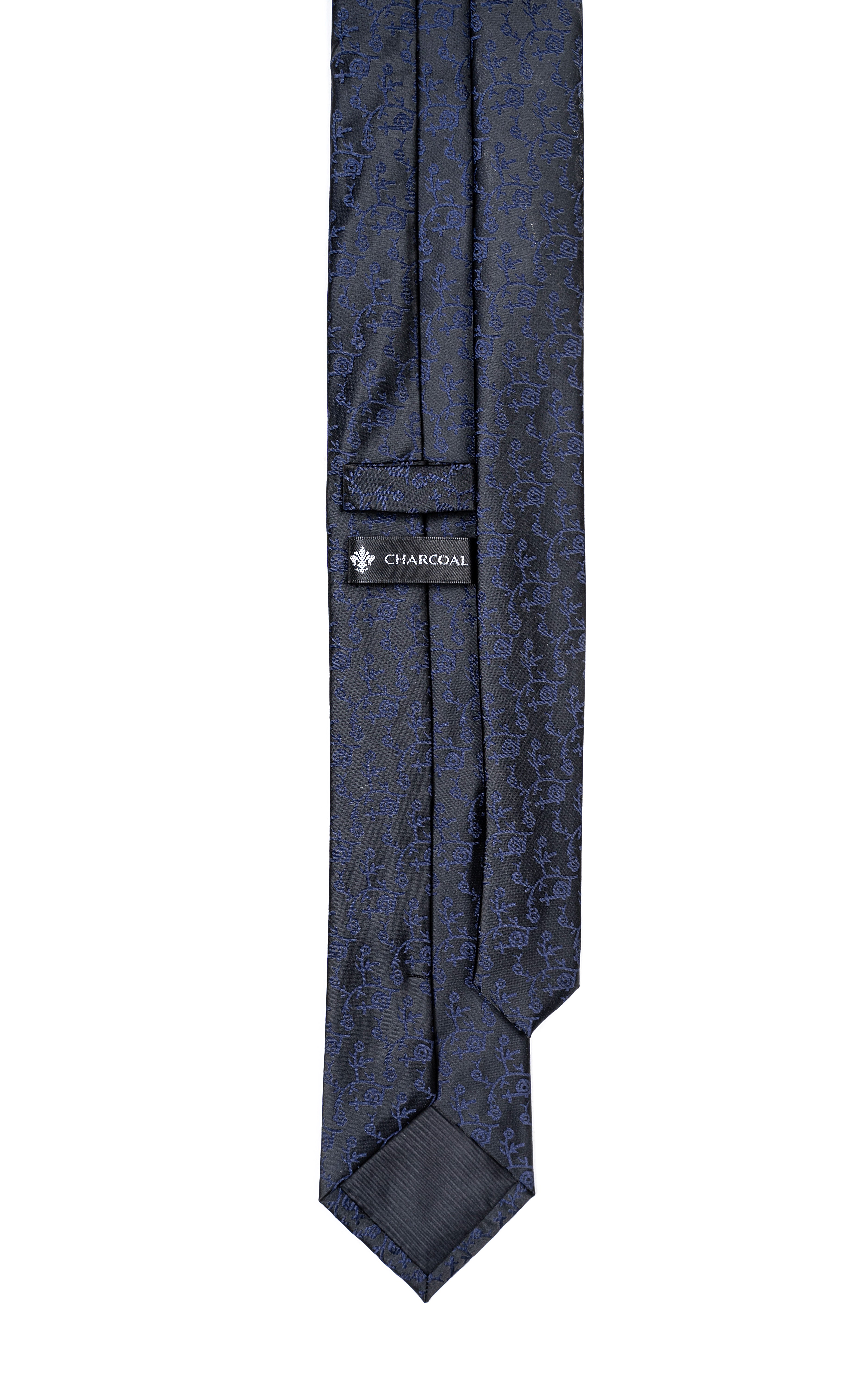 Poly silk tie, charcoal lining label visible, dark patterned fabric