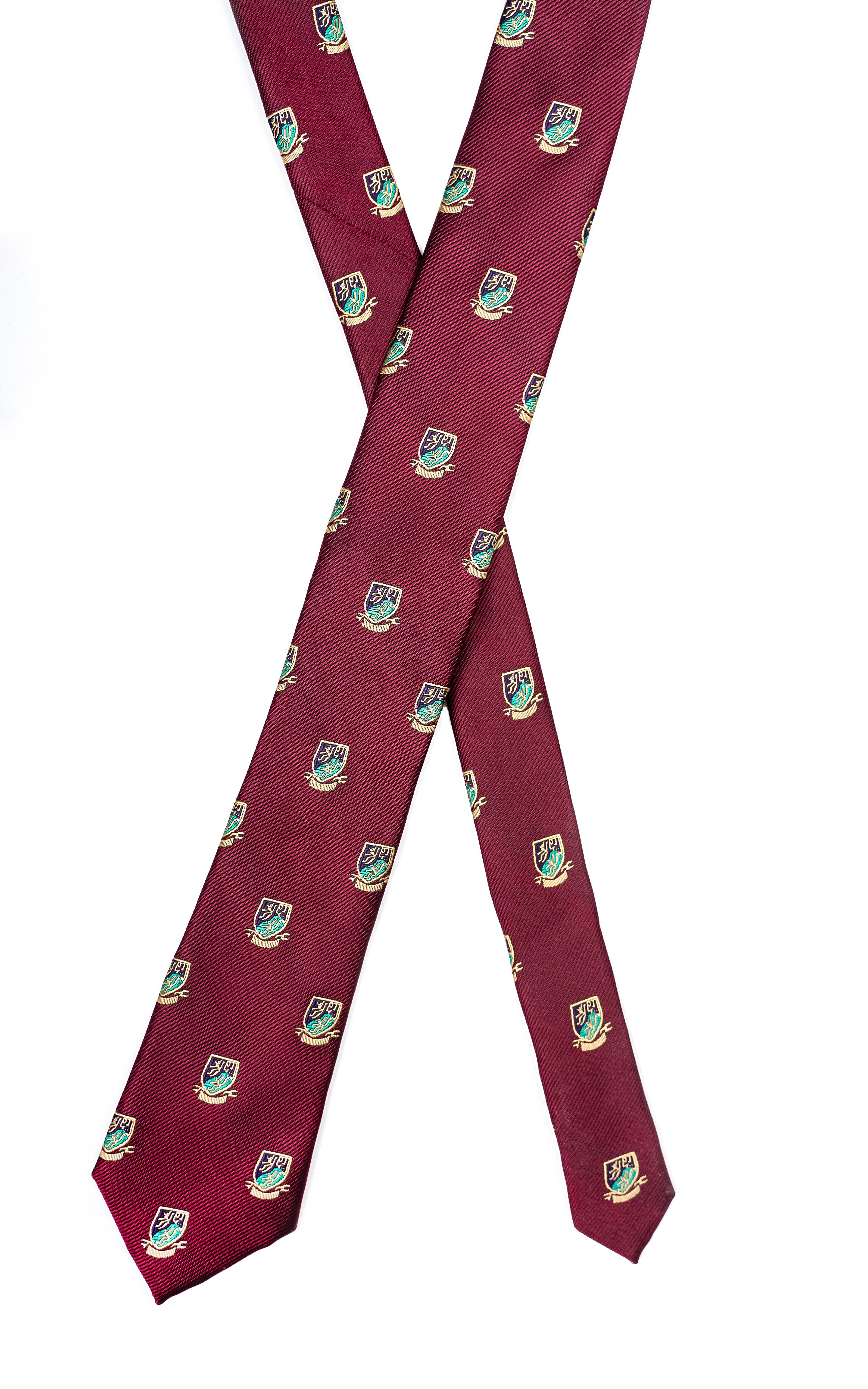 Poly silk tie laid flat in maroon with repeating green crest motifs