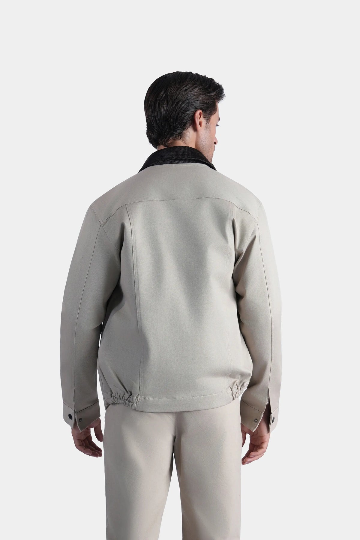 Back view of khaki full-sleeve jacket with stand collar and hem drawstring