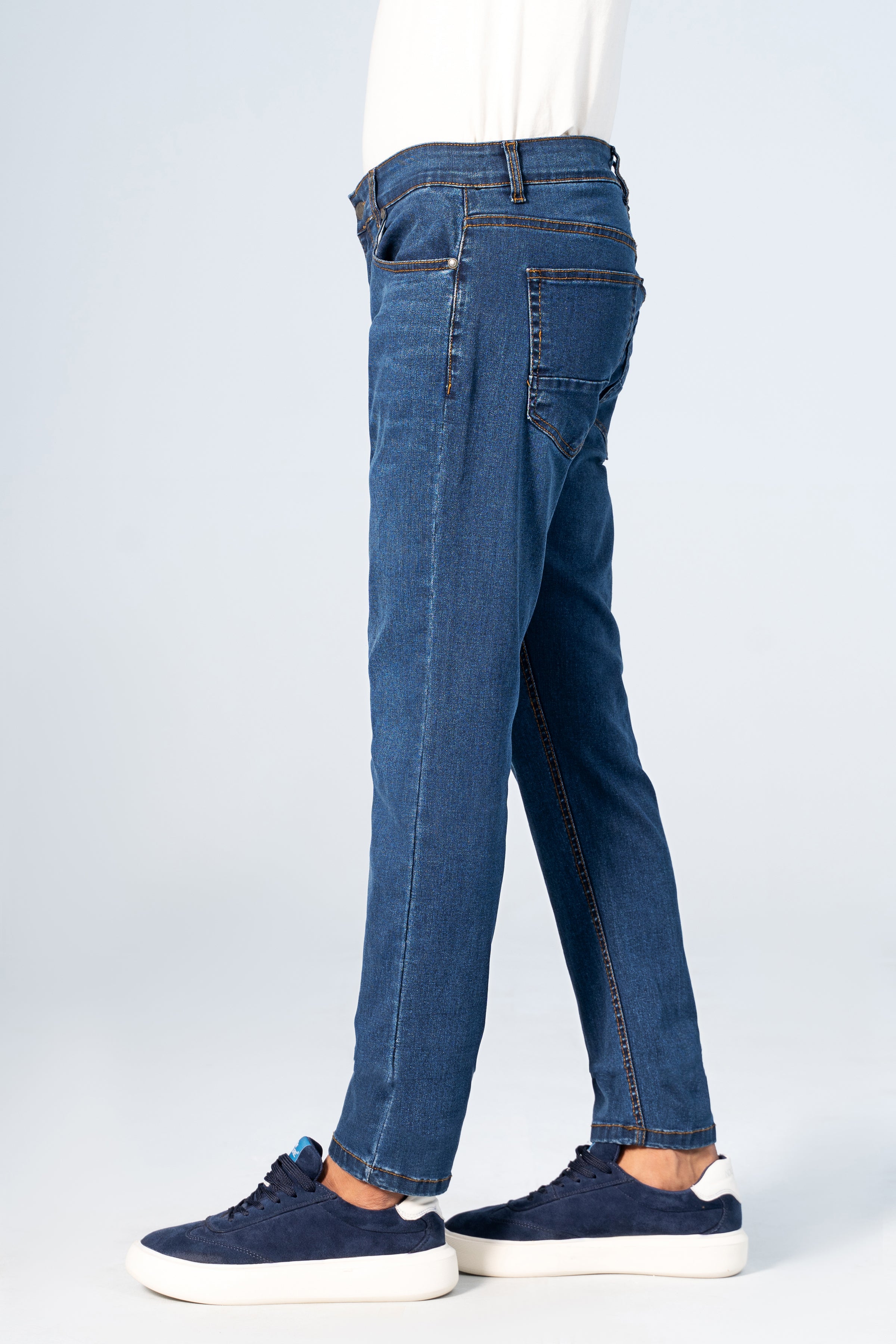 Slim-leg blue denim jeans back view with yoke seam, back pockets, belt loops