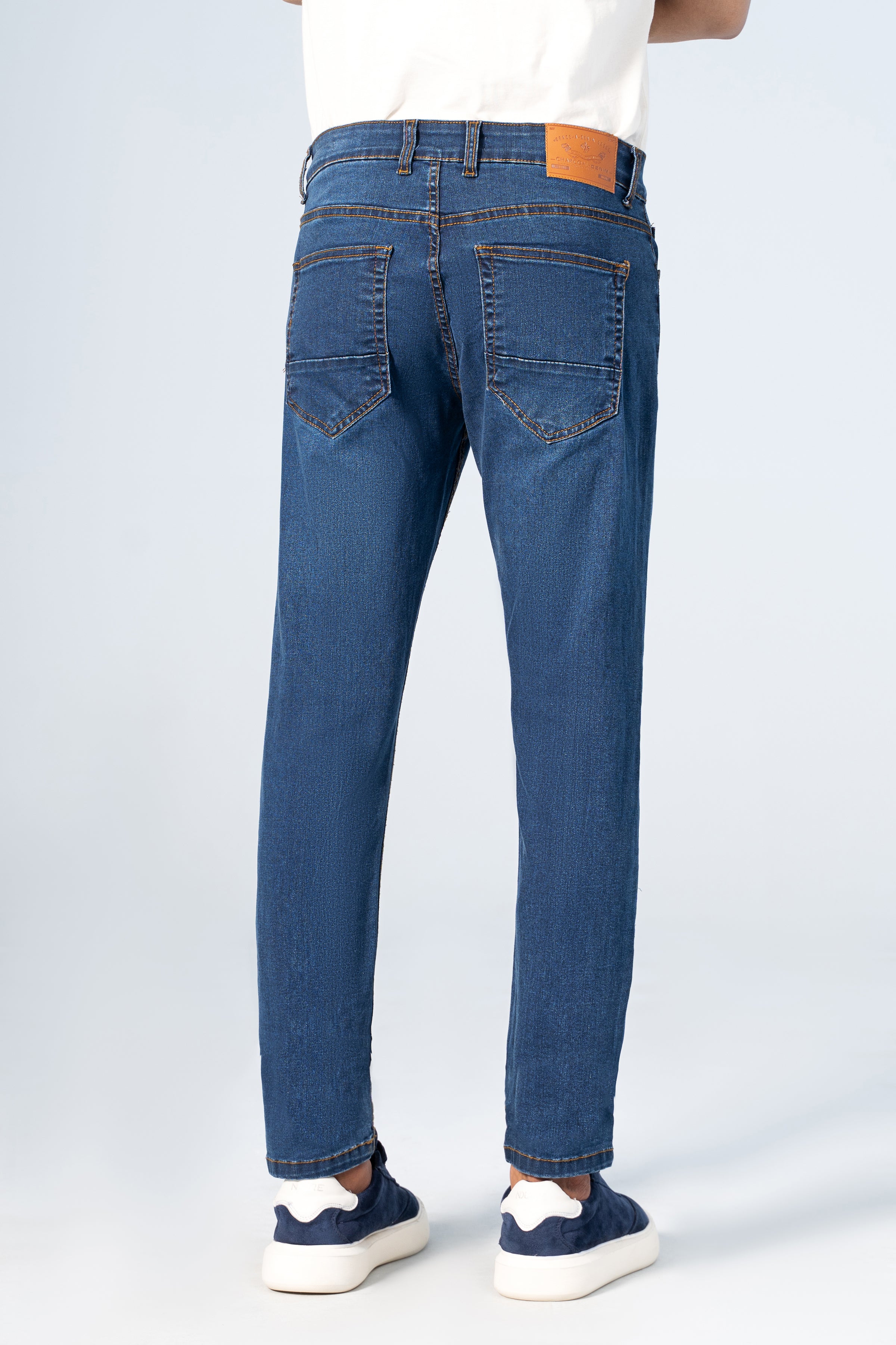 Slim-leg blue denim jeans rear view, stitched back pockets and tapered slim legs