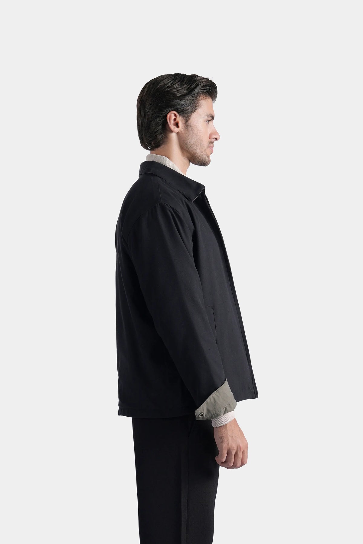 Black reversible collar jacket side view with olive lining at cuffs and hem