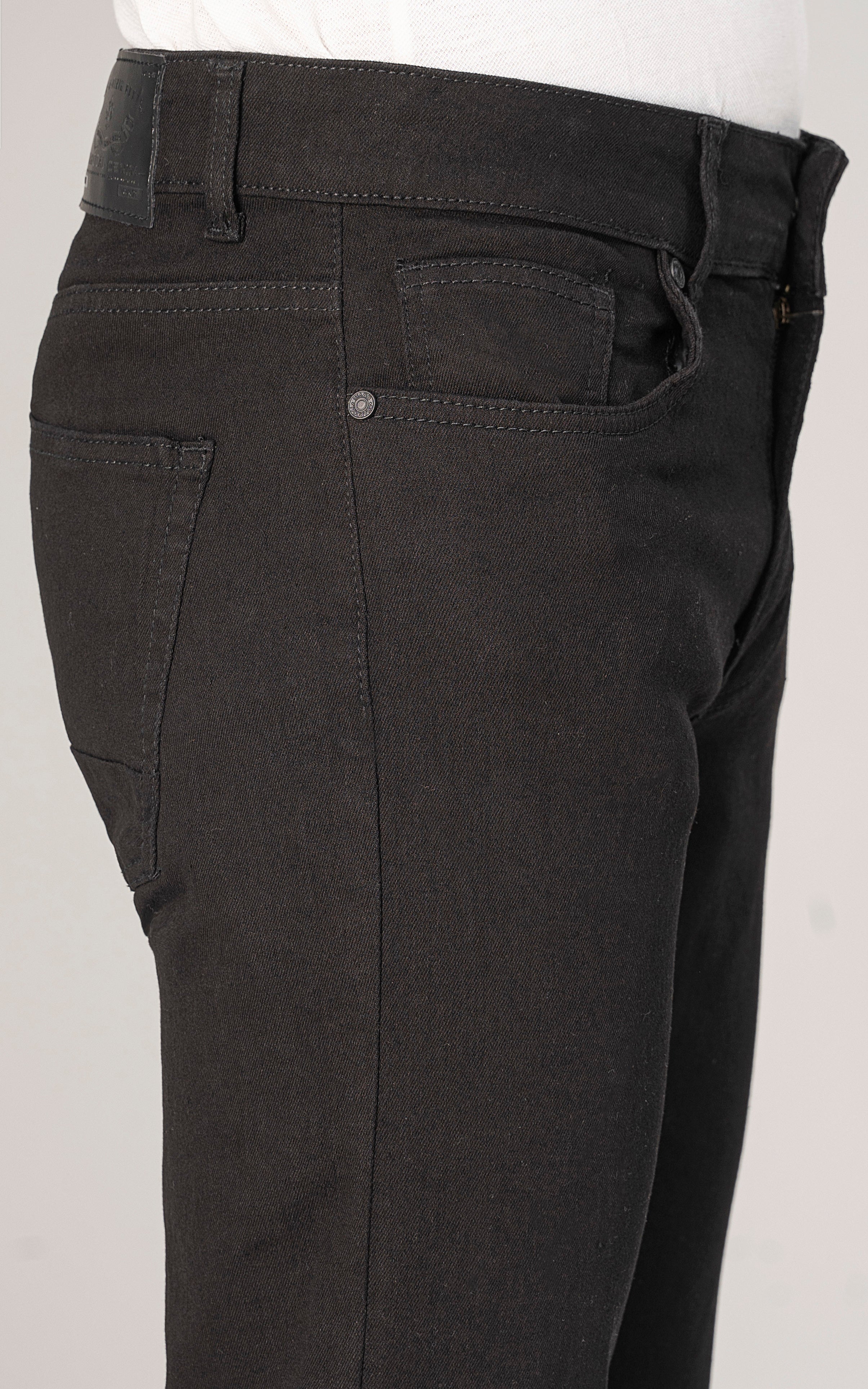 Close-up of black slim-fit jeans front with button waist and denim stitching