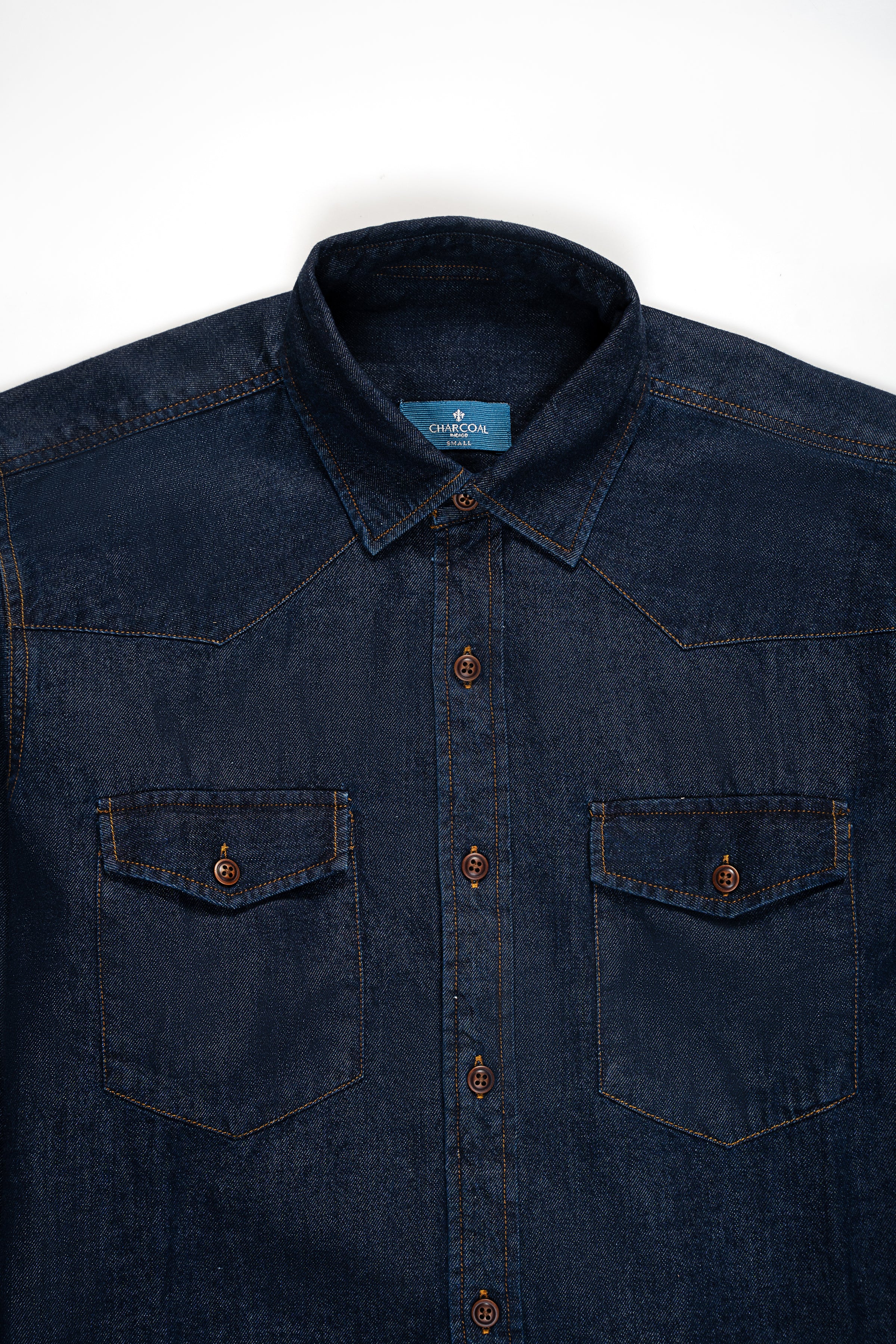 Blue-black denim button-up shirt front view with two chest flap pockets and dark buttons