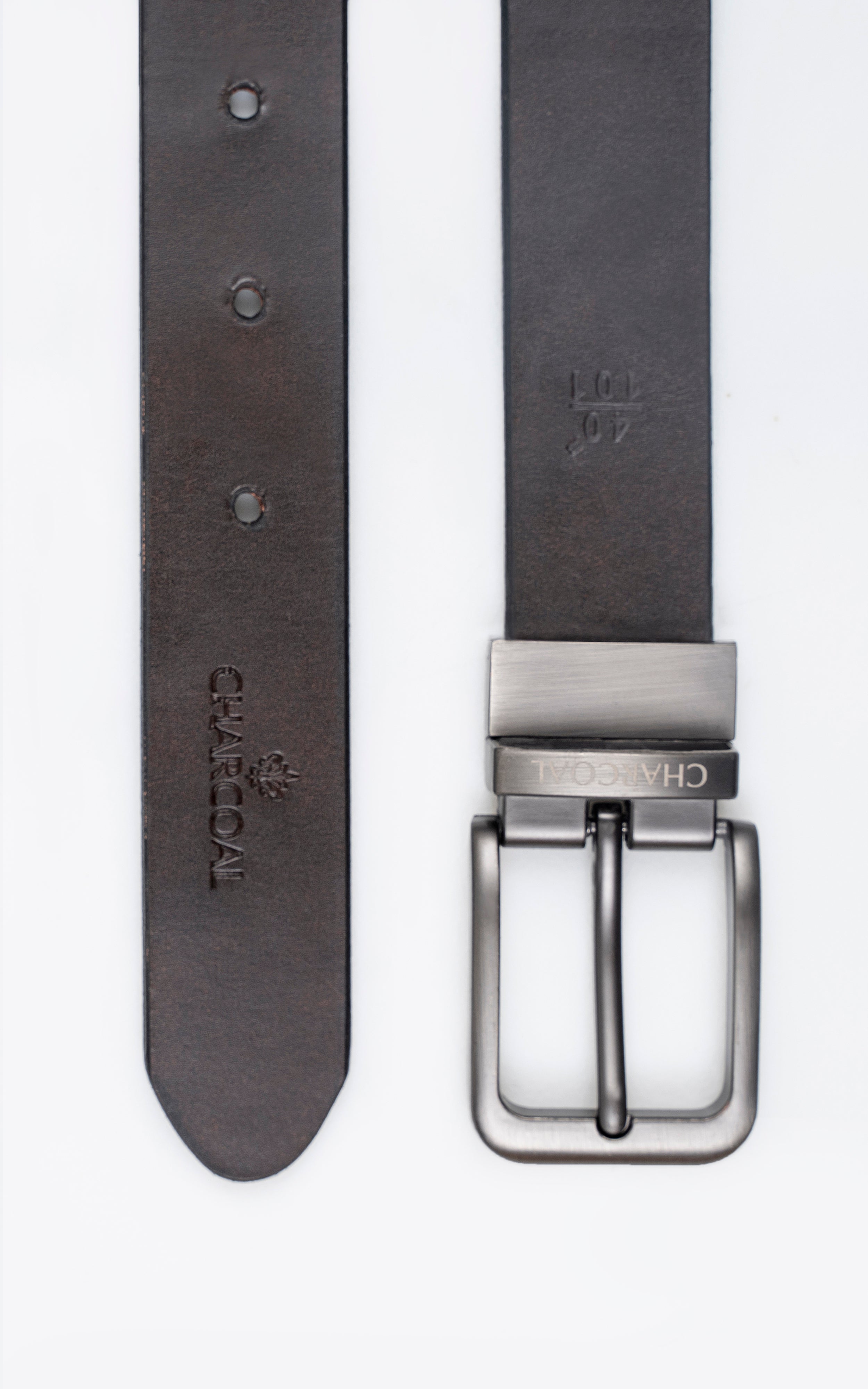 Leather belt buckle on dark strap with embossed marks and three adjustment holes