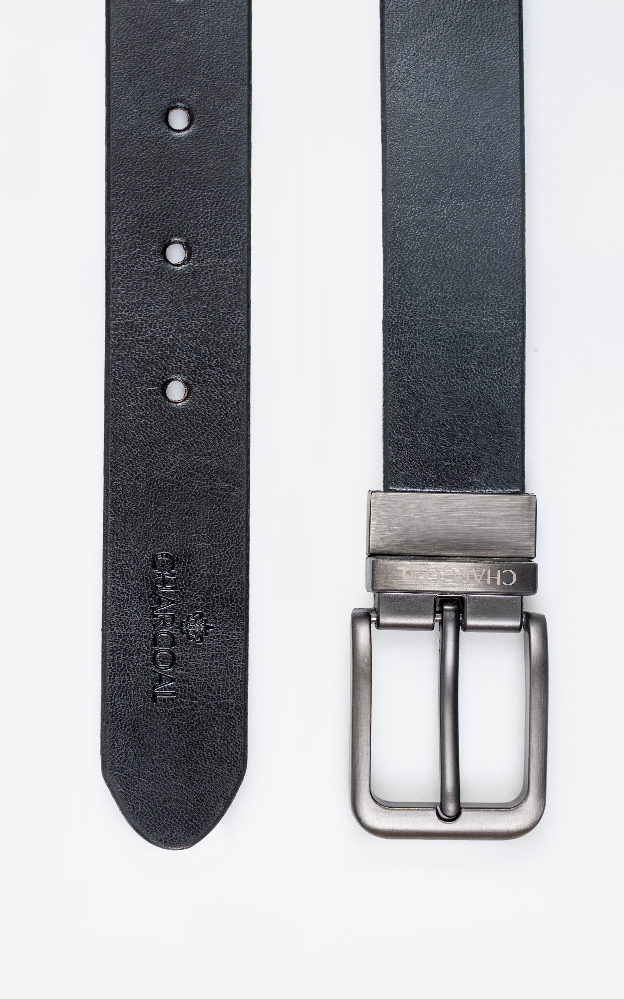 Reversible leather belt detail, dark strap with three holes and silver buckle hardware