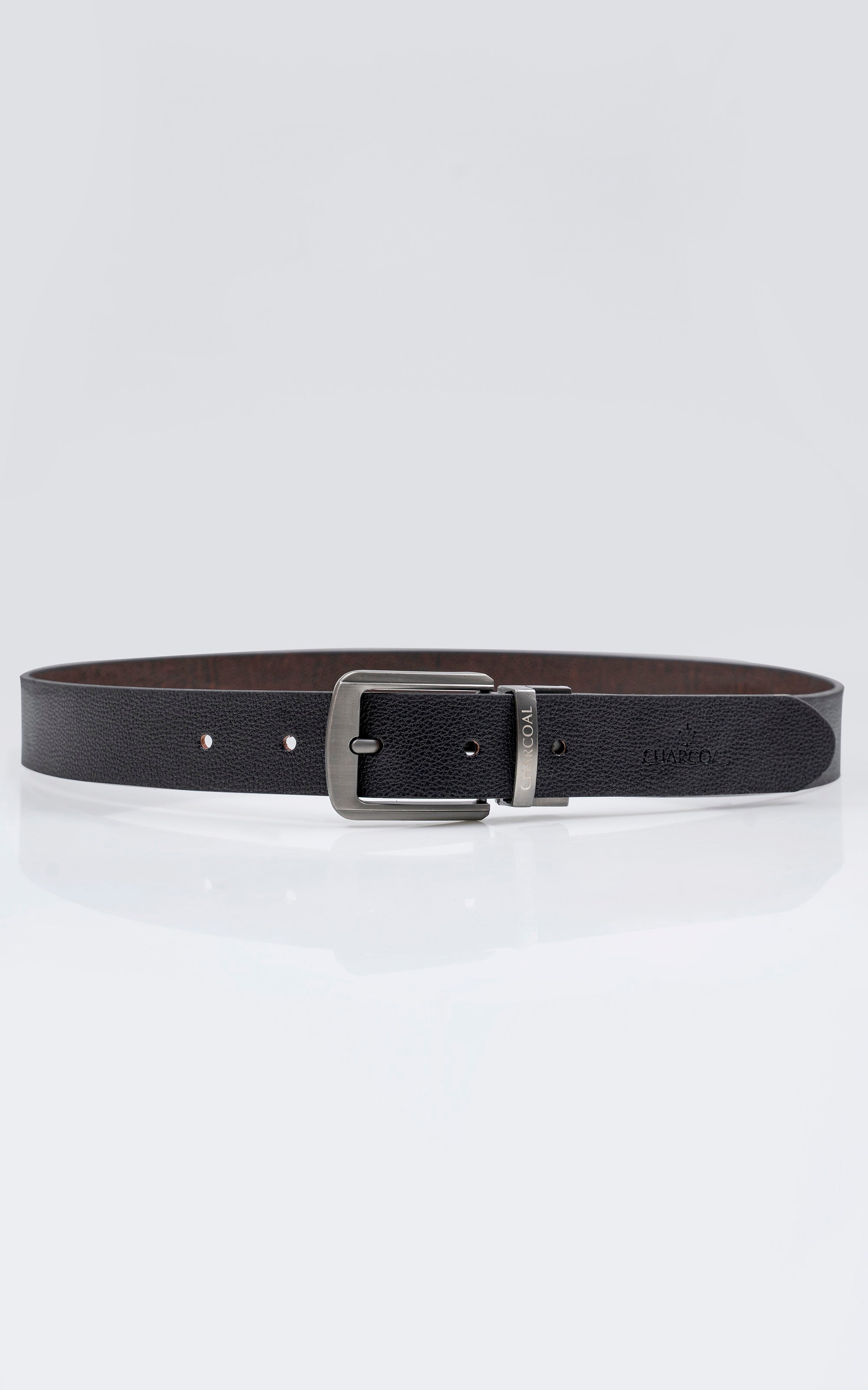 Reversible belt showing black outer, brown inner, and silver buckle with holes.