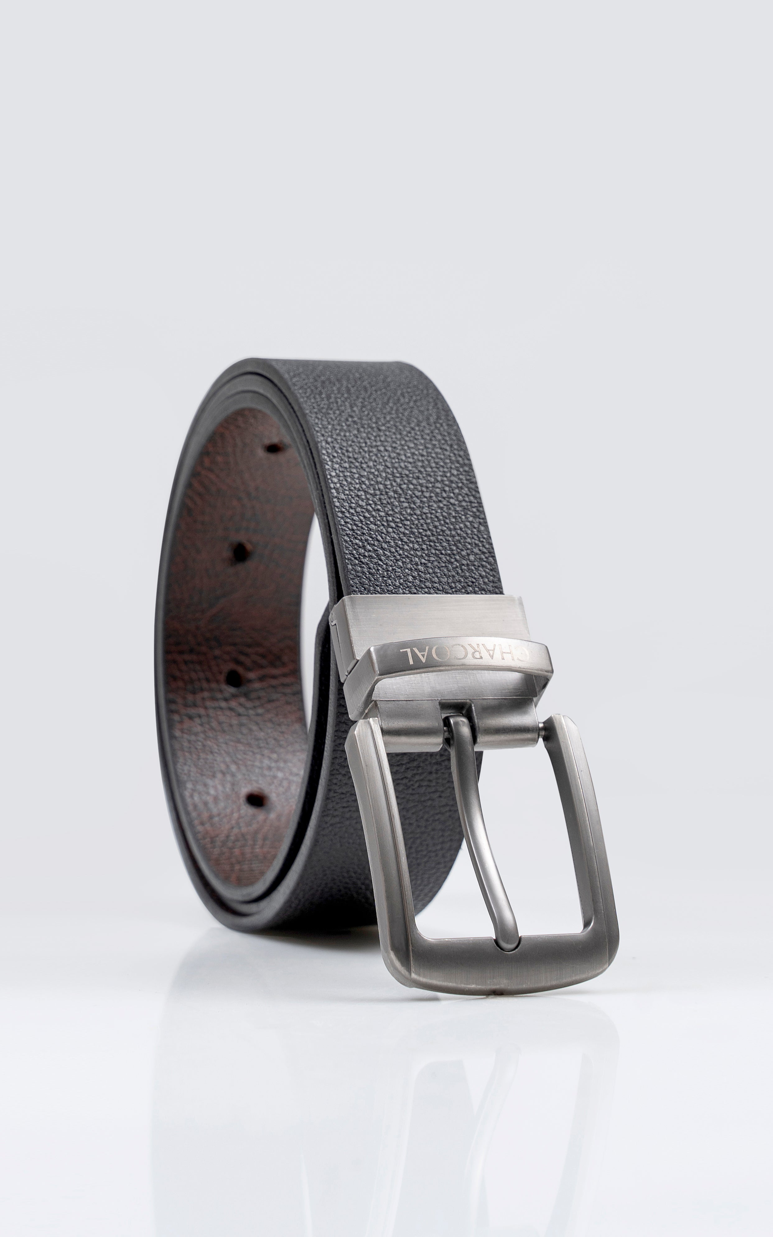 Reversible belt with black textured strap and silver buckle, visible top side.
