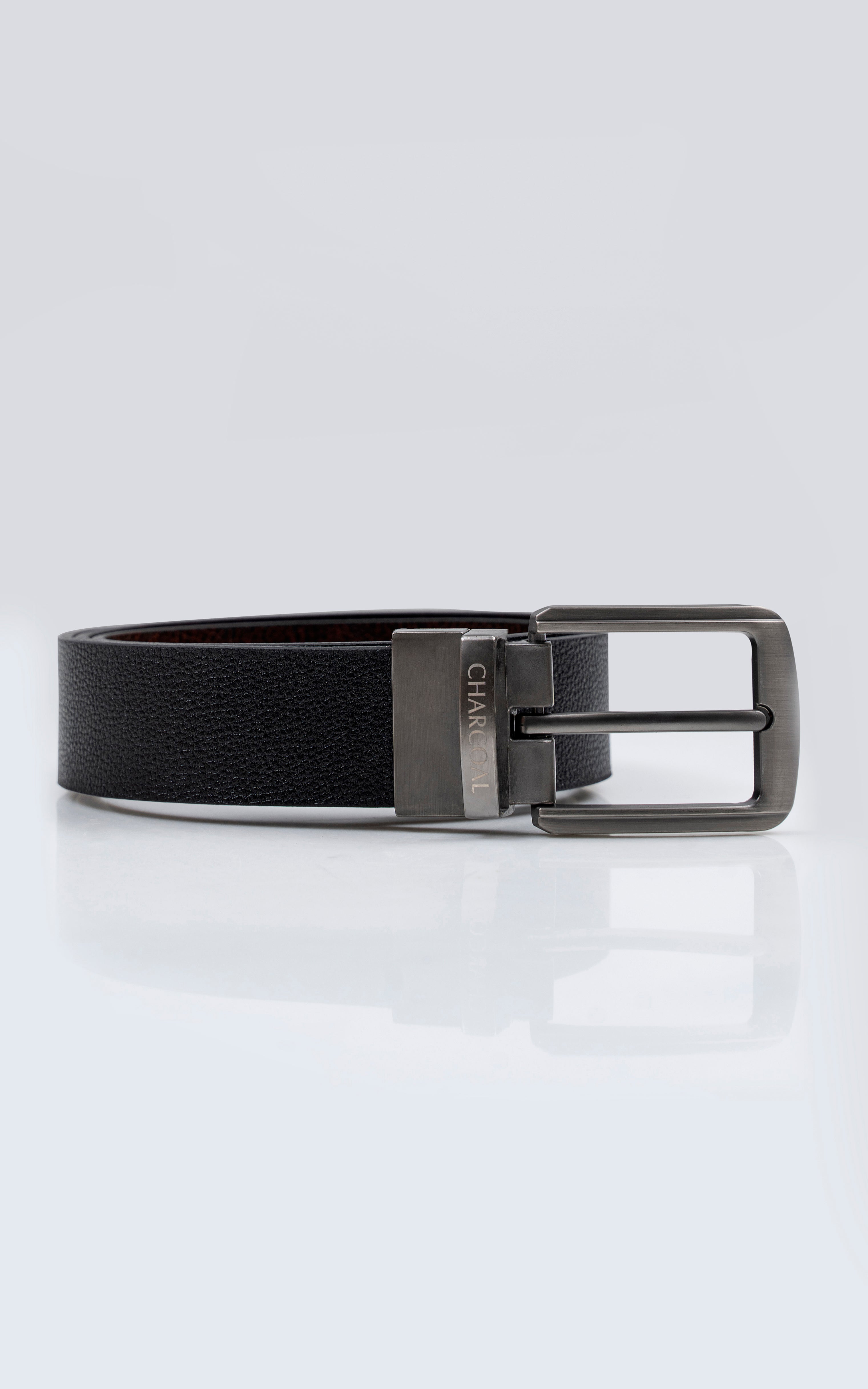 Reversible belt with black strap and silver rectangular buckle, side view.