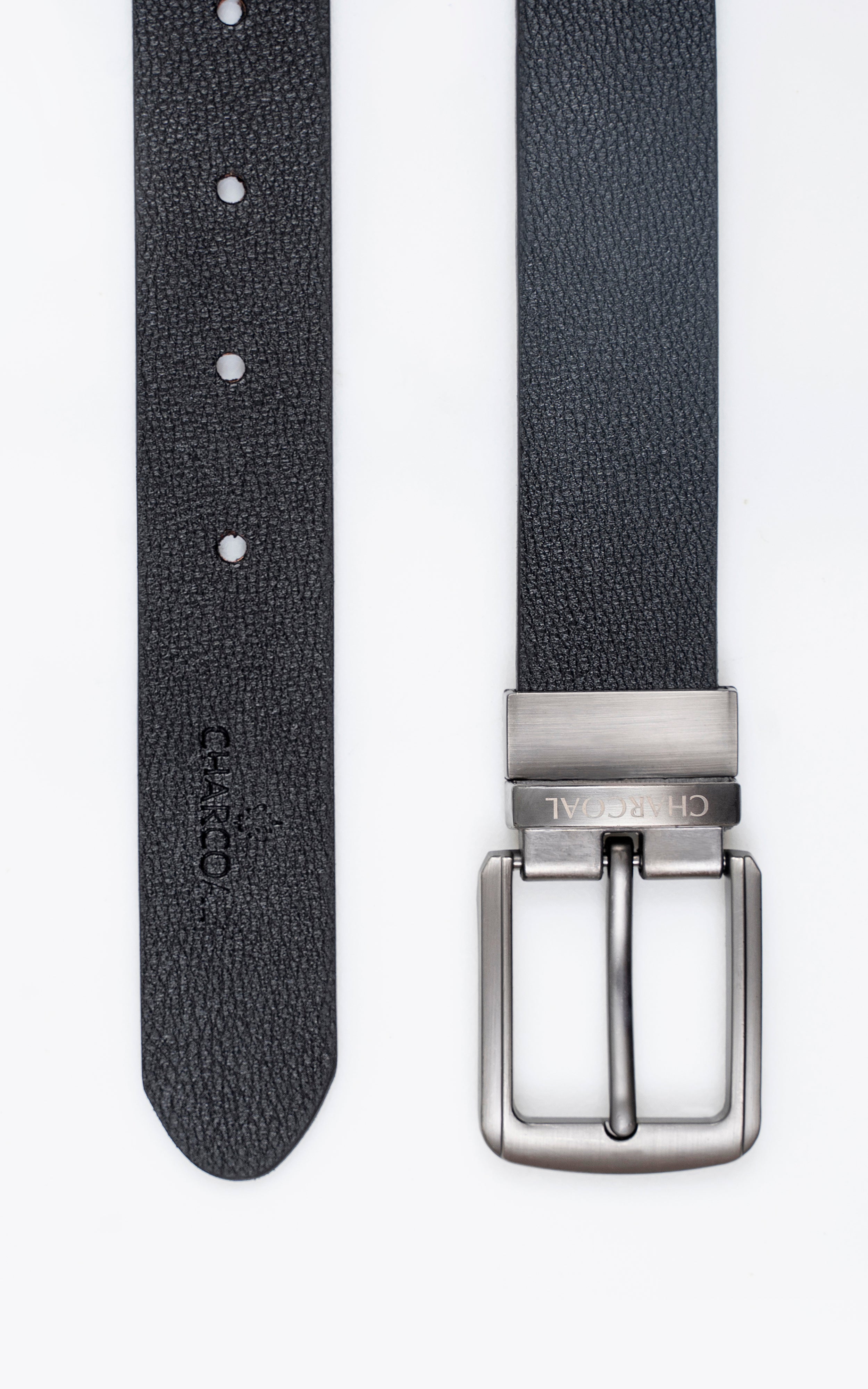 Reversible belt close-up of black textured strap, metal buckle and hole row.
