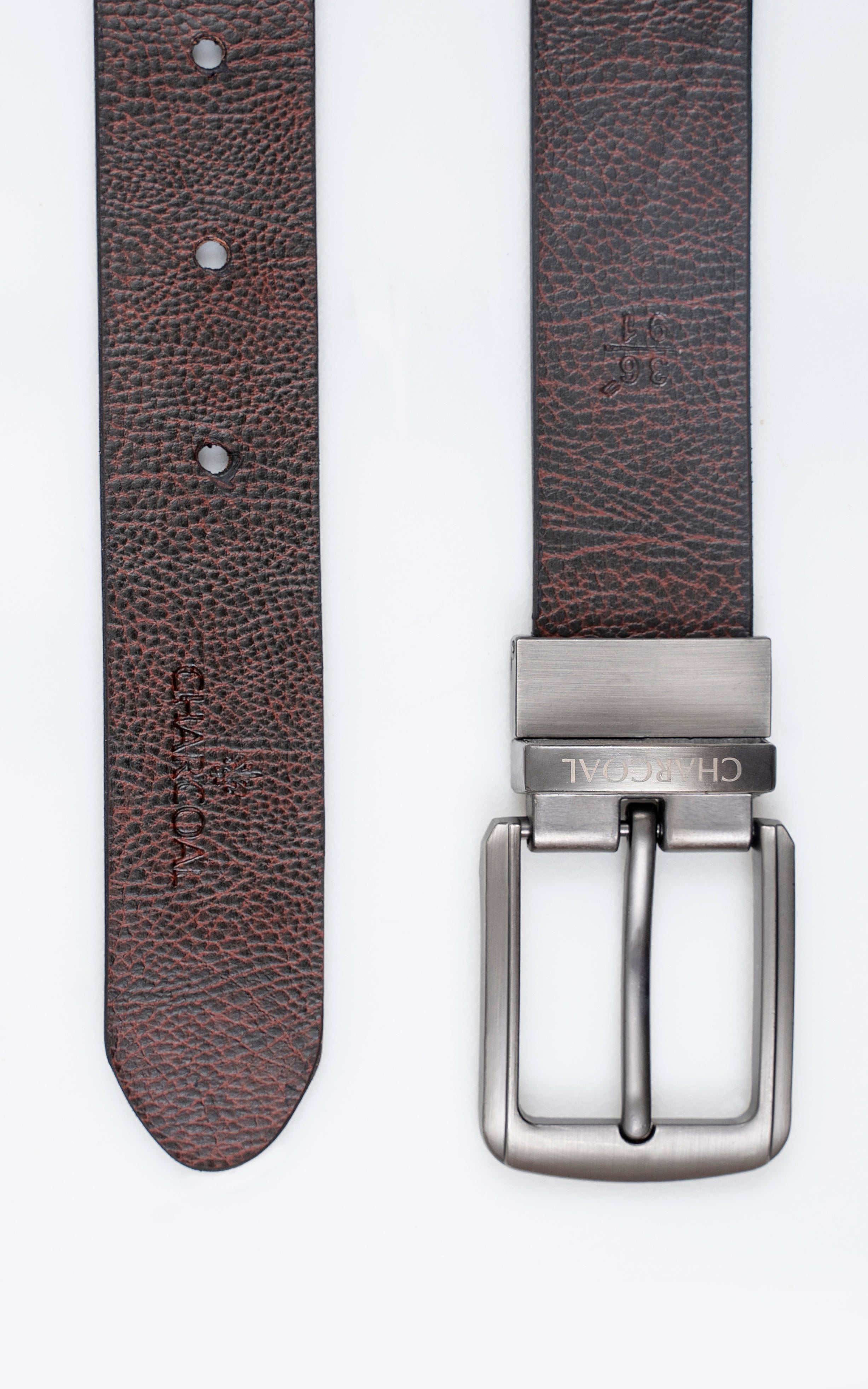 Reversible belt close-up of brown textured strap, metal buckle and hole row.