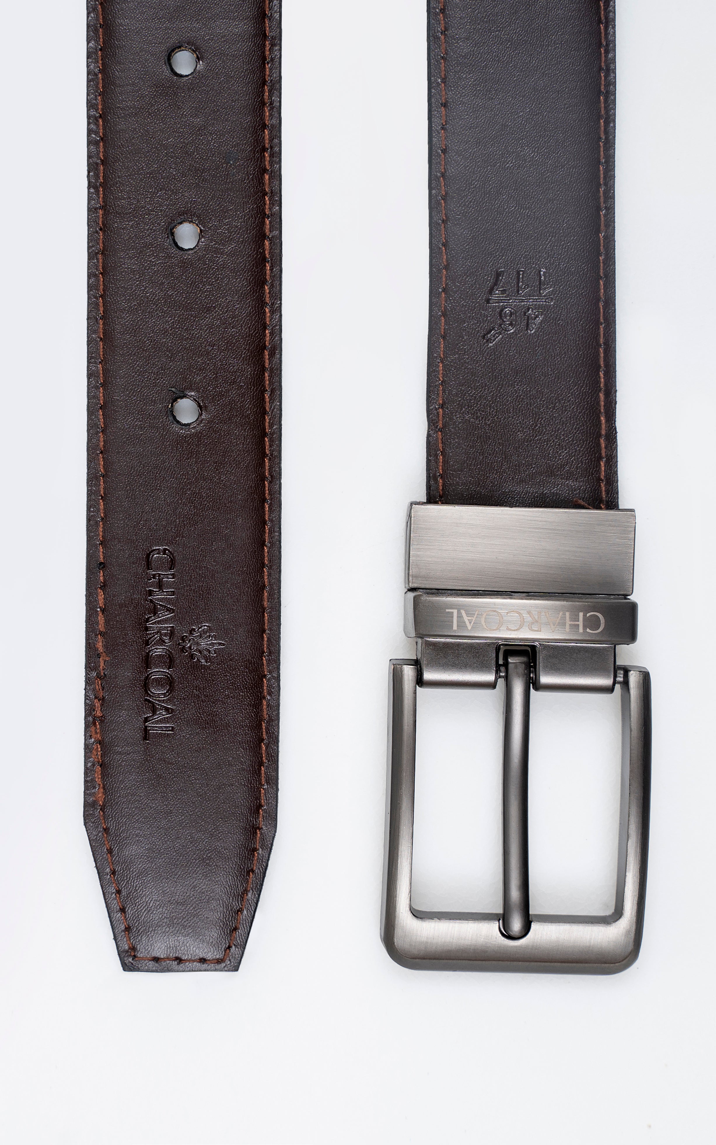 Leather belt close-up: brown reverse strap with stitched holes beside silver buckle