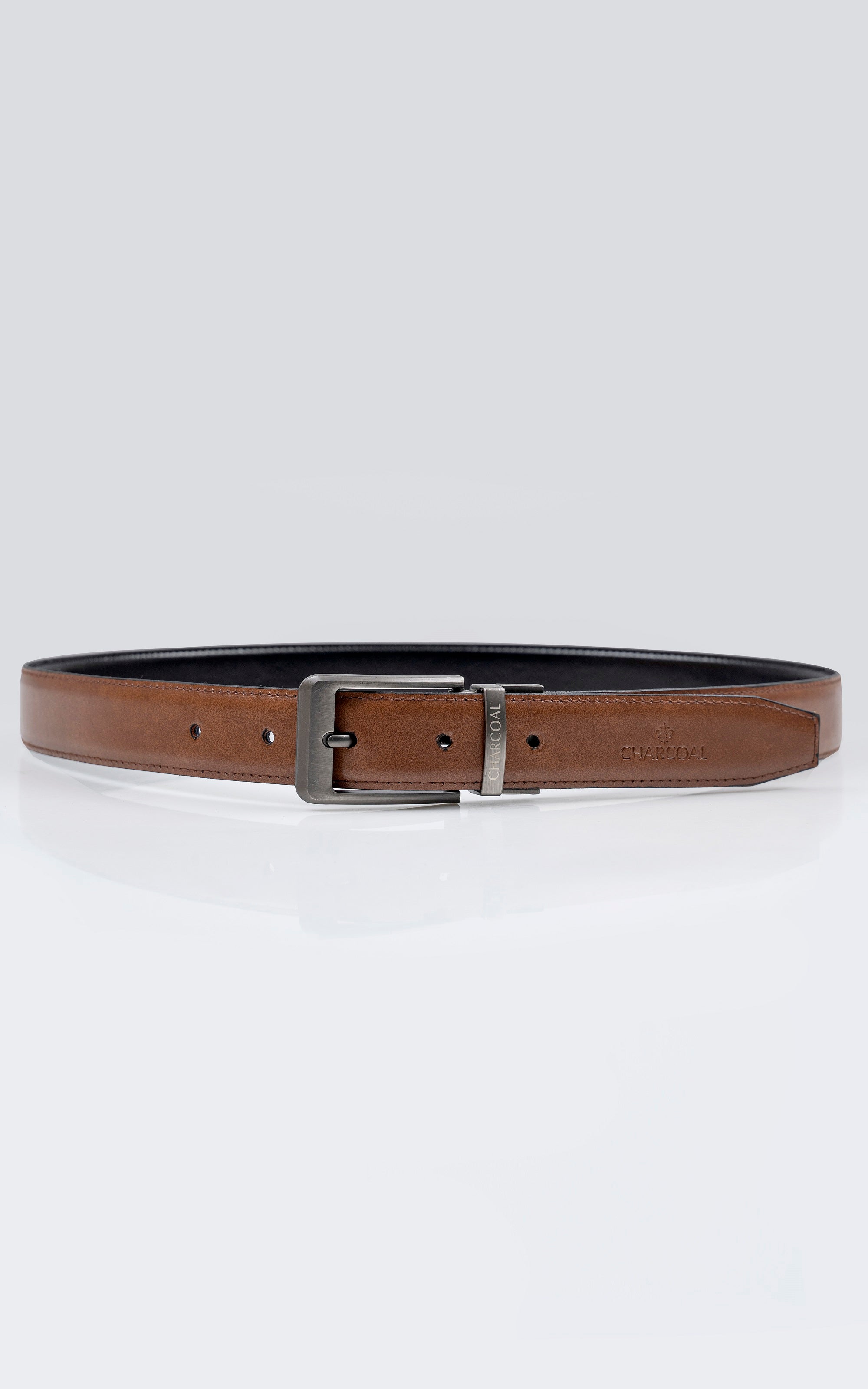Reversible leather belt with tan-brown underside and dark top, silver buckle.