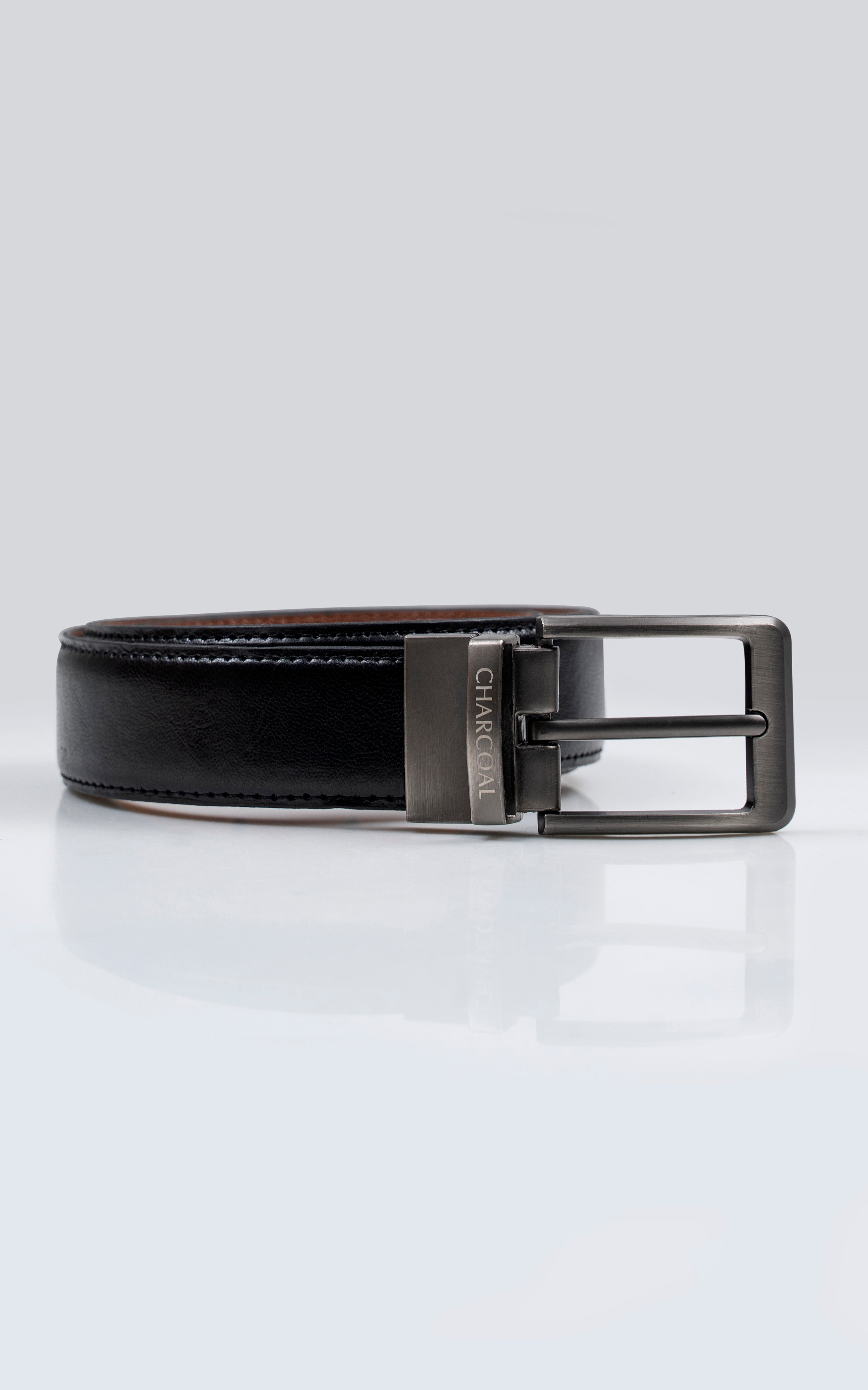 Reversible leather belt in dark color with rectangular silver buckle.