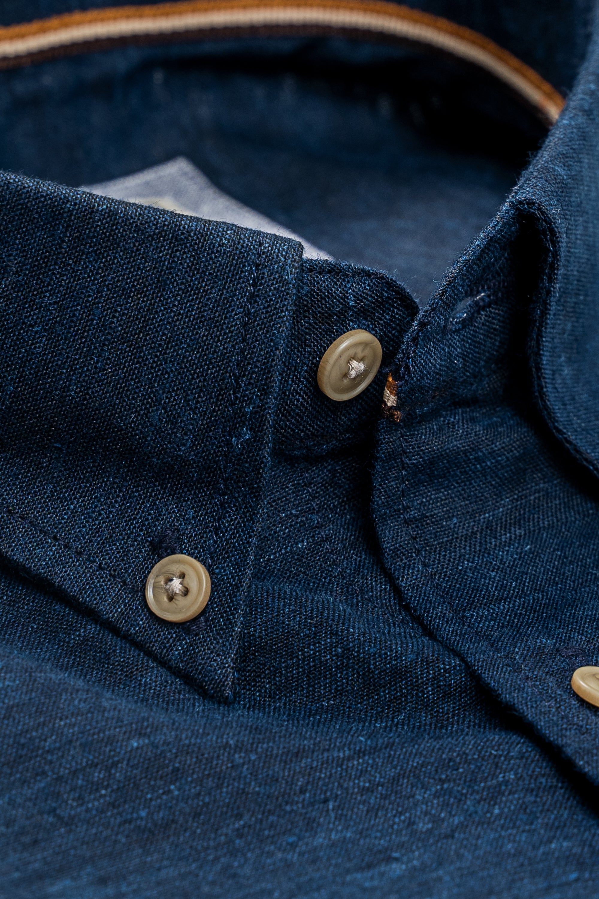 Navy linen shirt close-up of collar stand and button placket with tan buttons