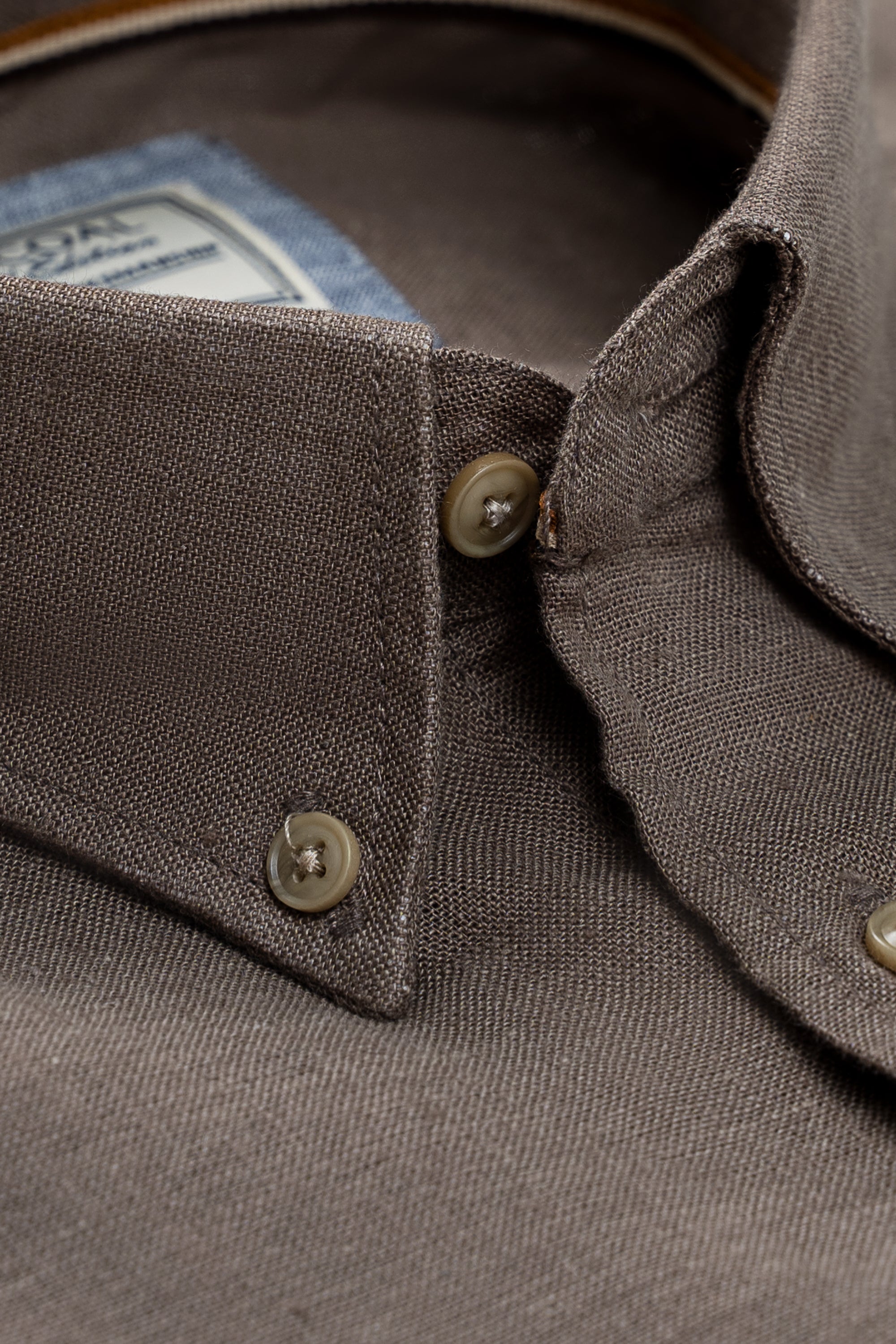 Close-up of brown linen shirt collar and buttons with folded cuffs