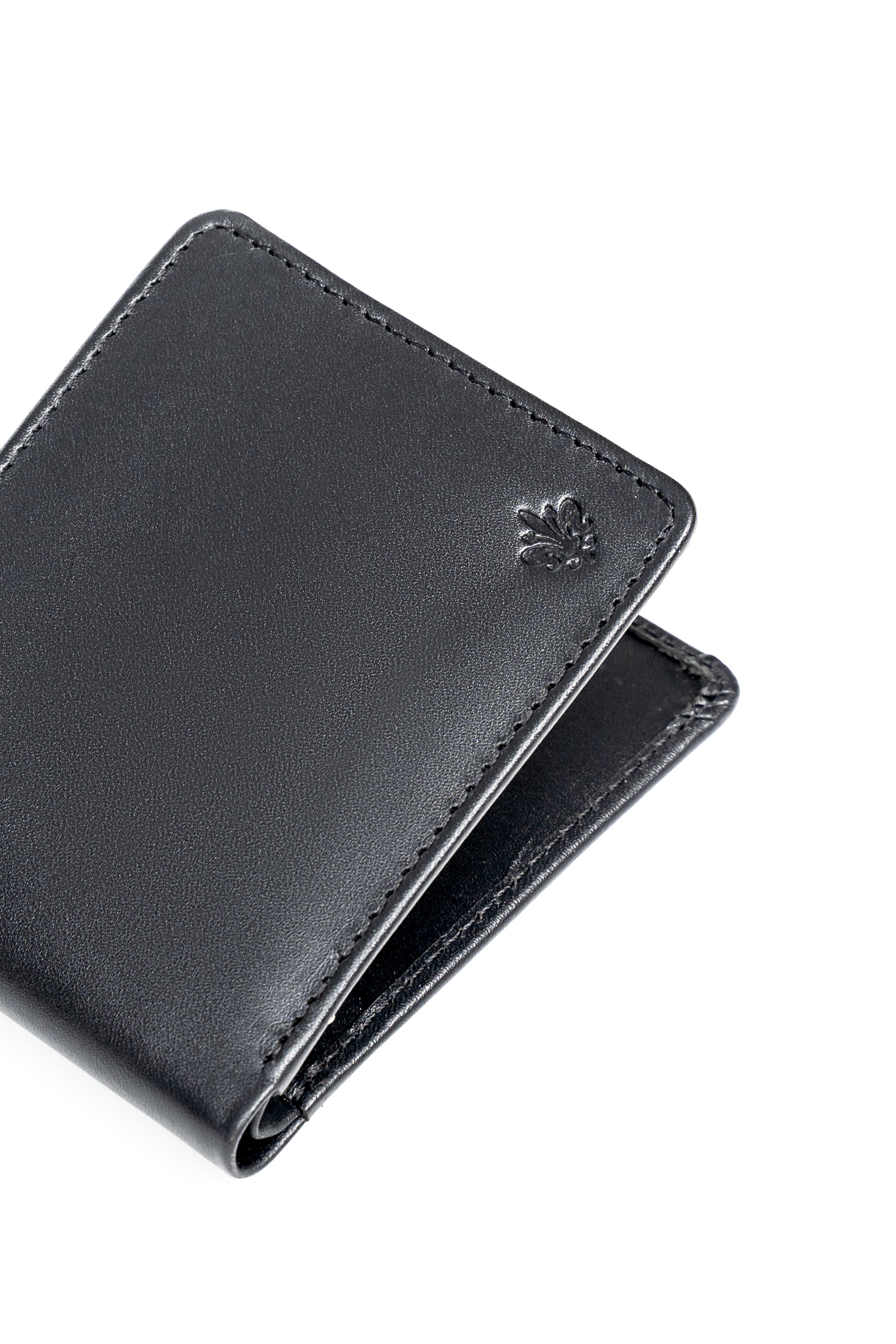 Black leather bifold wallet with embossed clover on front, angled close-up.