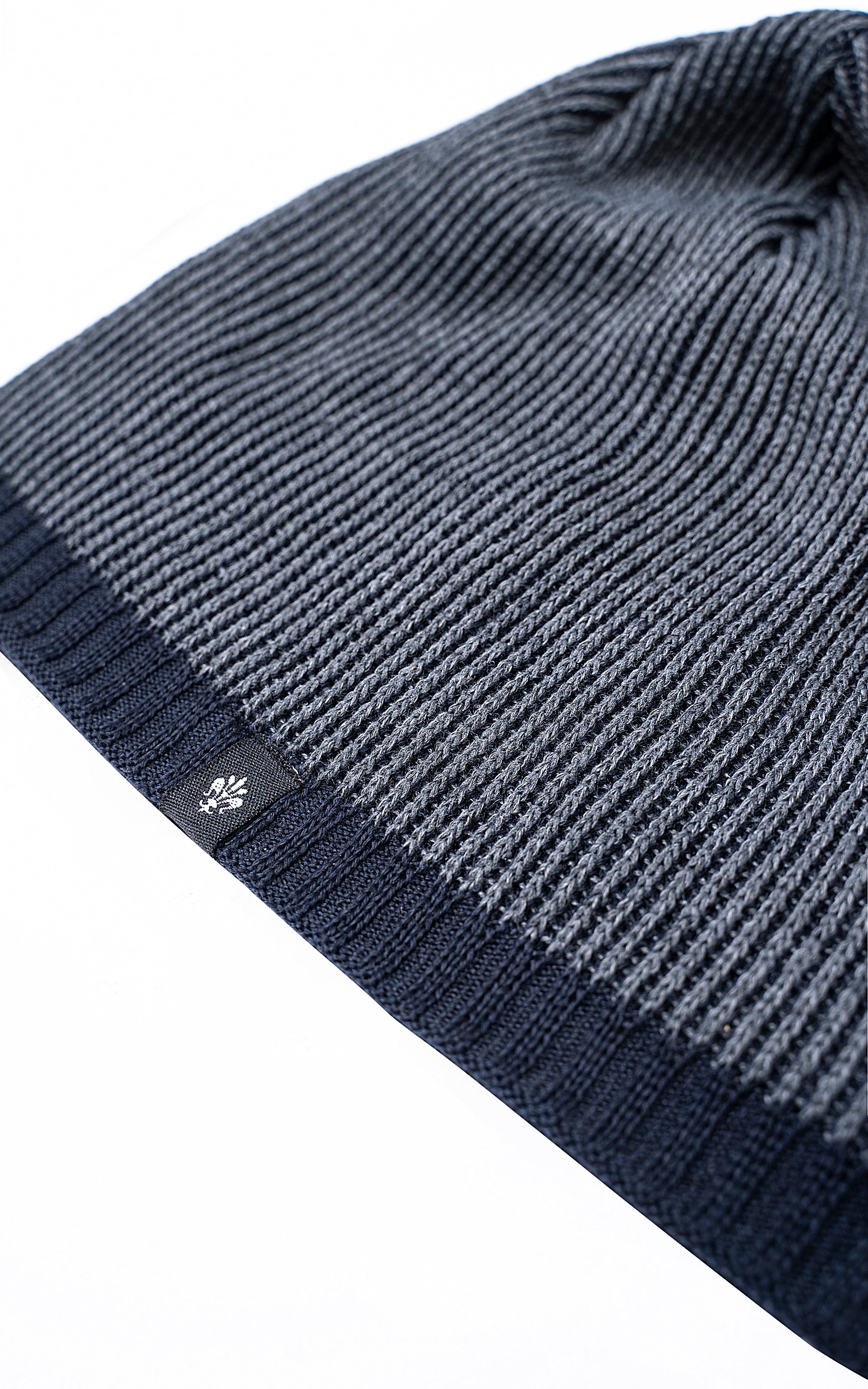 Wool cap cuff close-up with small stitched logo and ribbed dark blue knit