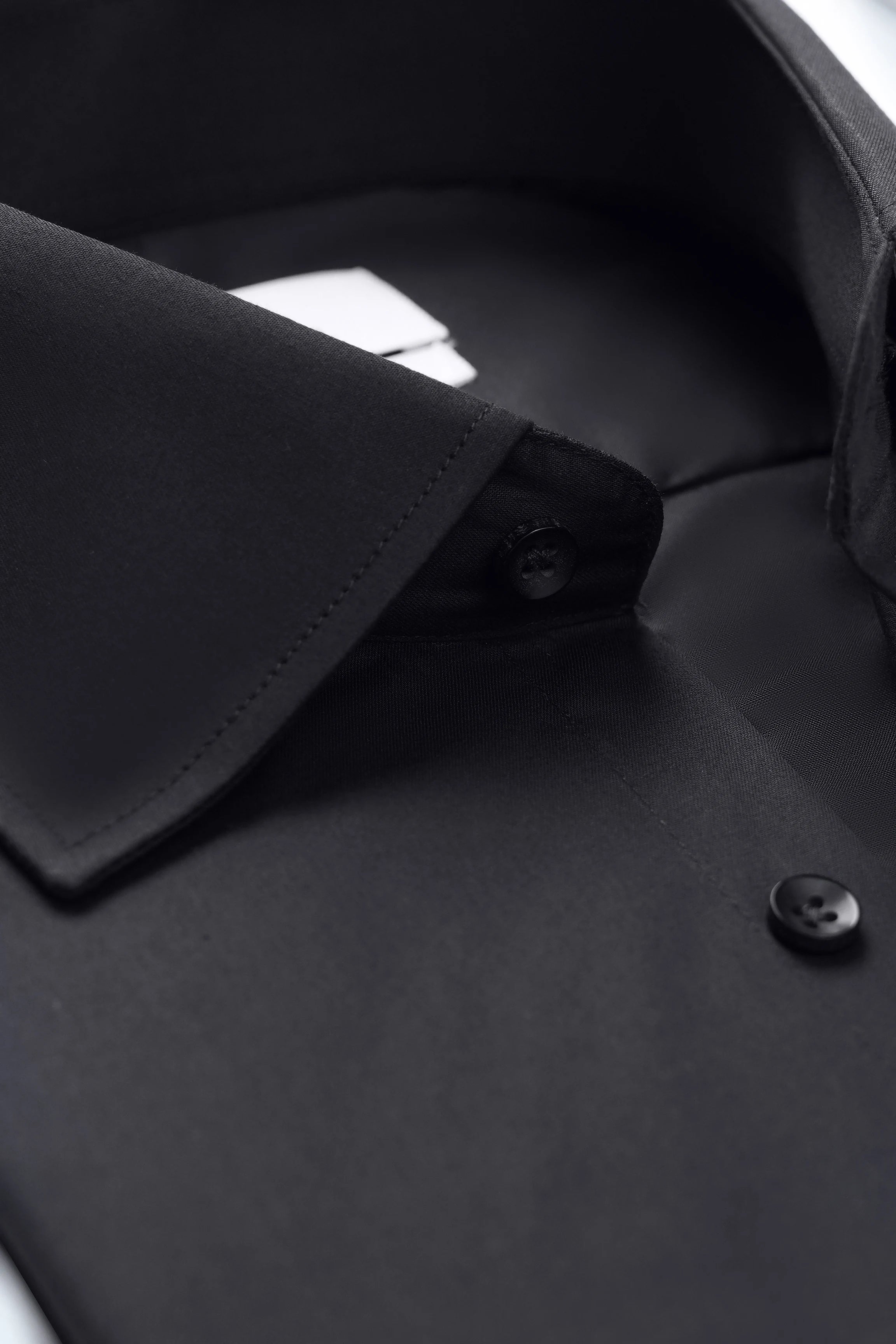 Black dress shirt collar and placket close-up with dark buttons