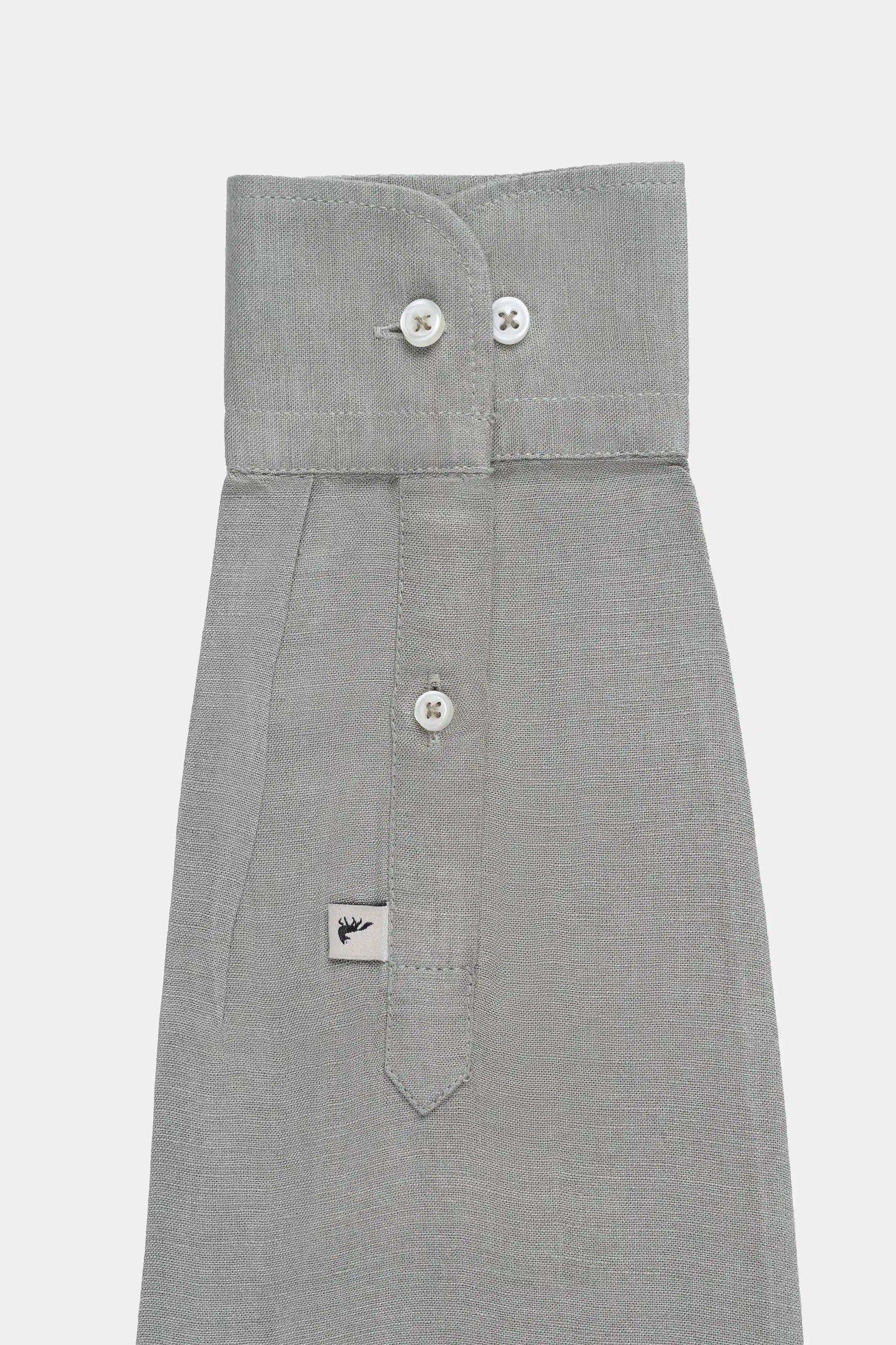 Light olive linen shirt front with collar tabs, buttons, and patch pocket