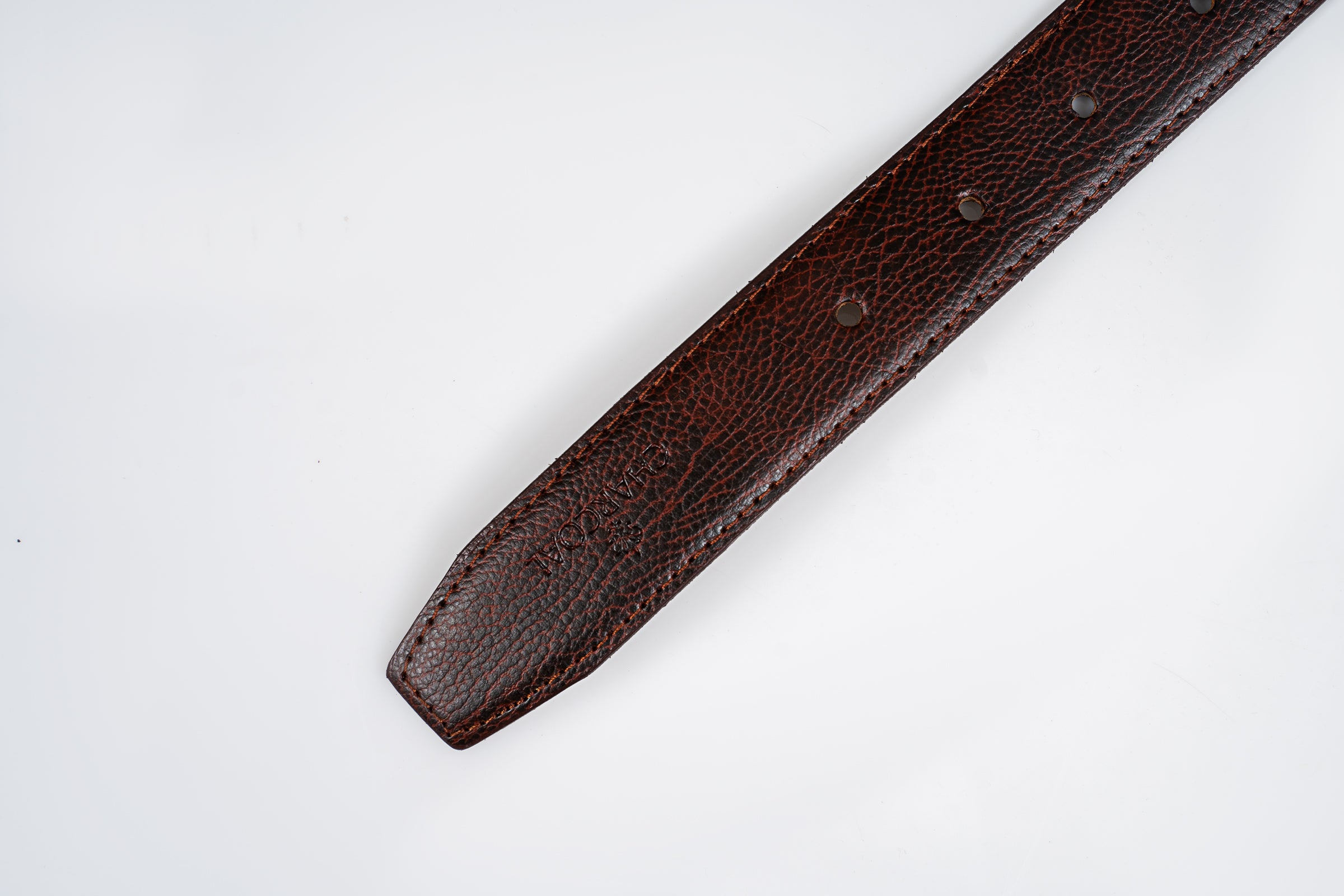 Brown leather belt strap detail with stitched edge and small punch holes