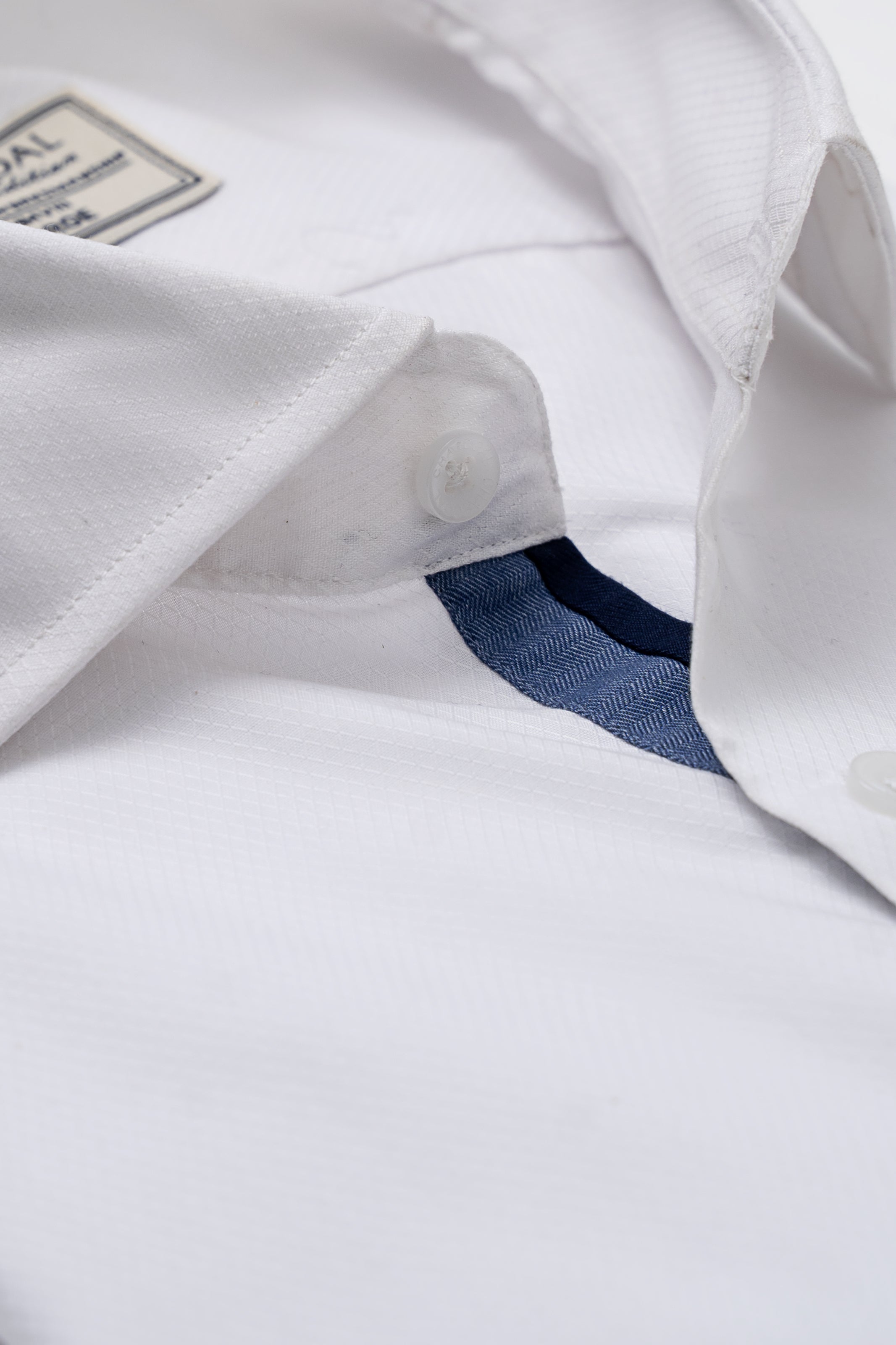 White shirt cuff and placket detail with dark blue inner fabric and button